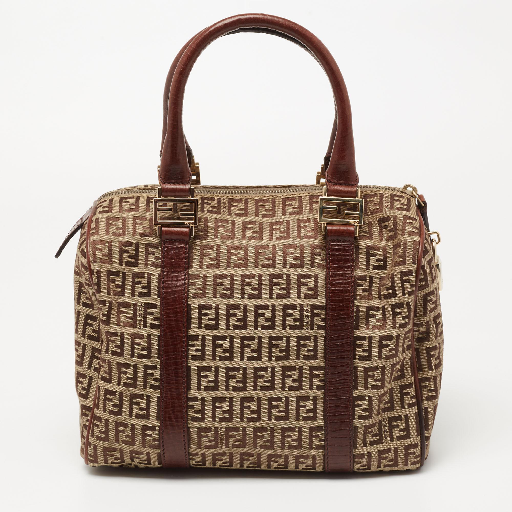 This Forever Bauletto bag from Fendi is the perfect bag you've been searching for, all this while! The brown and beige creation is crafted from Zucchino canvas and leather and features dual top handles that are detailed with gold-tone brand logo