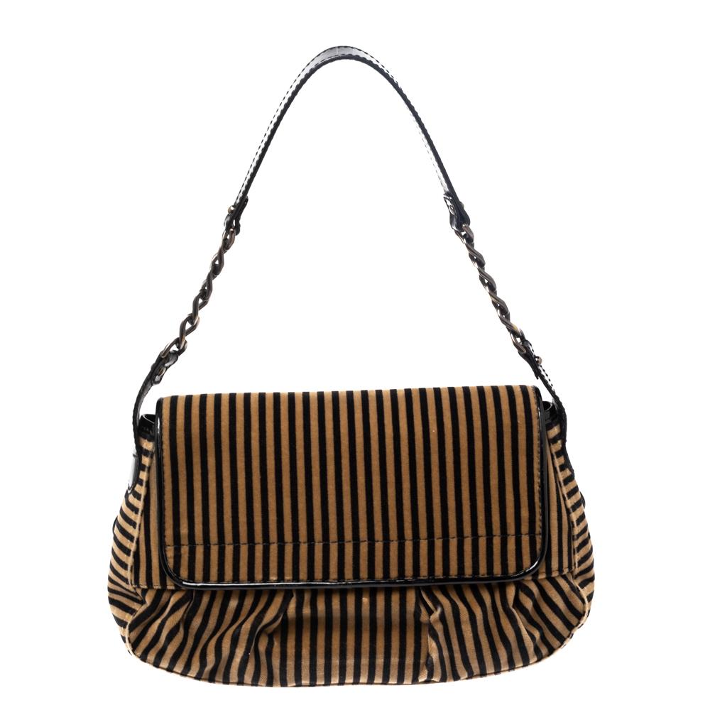 For weekend errands and casual outings, this B Bis shoulder bag from Fendi is both stylish and practical. It is crafted from striped velvet and features a calfhair strap with buckle accents at the front to secure the fold-in flap. The bag is lined
