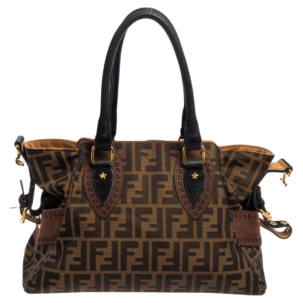 This Chef De Jour bag from the house of Fendi is designed in a brown Zucca canvas body and detailed with studs on the 'FF' logo making it a statement piece. It comes topped with two rolled top handles. The spacious fabric-lined interior has a zipper