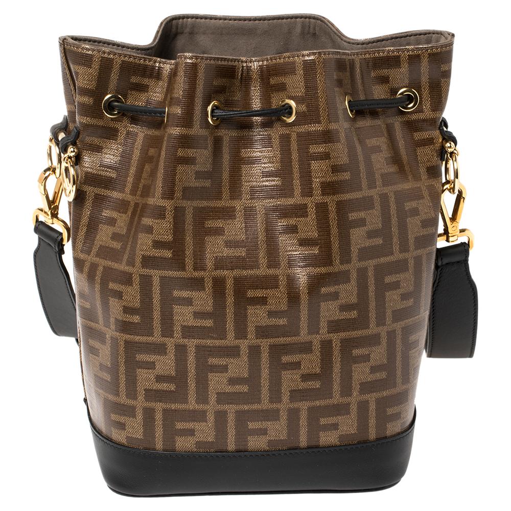 This practical and trendy bucket bag by Fendi is a must-have in every fashionista's closet! The Mon Trésor bag is crafted from Zucca canvas and leather in black and brown hues and features a drawstring closure that secures the well-sized suede