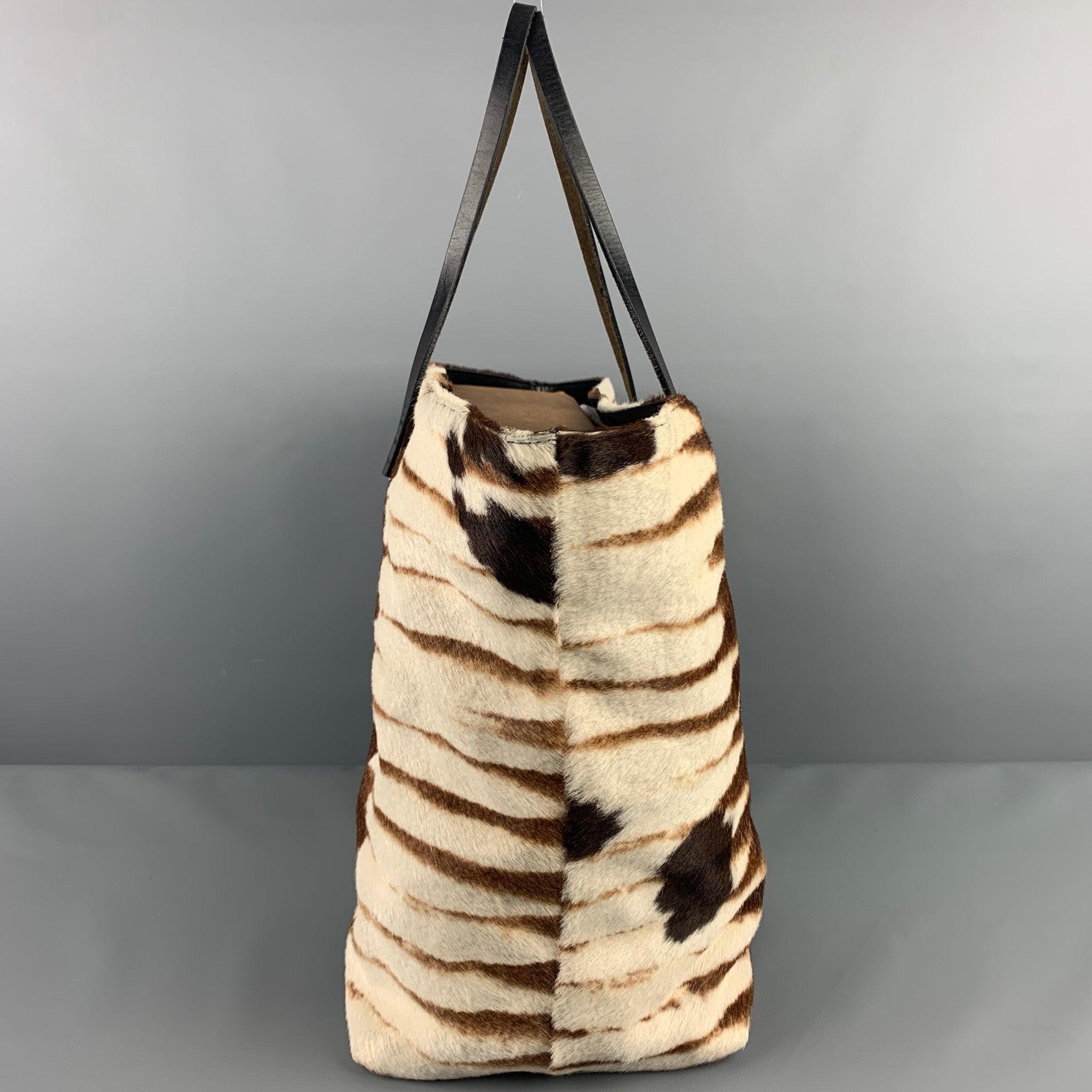 FENDI bag comes in a brown & cream zebra calf hair featuring leather top handles, inner pocket, and a snap button closure. Made in Italy.
Good
Pre-Owned Condition. Moderate discoloration at interior. As-Is.  

Measurements: 
  Length: 13.5 inches 