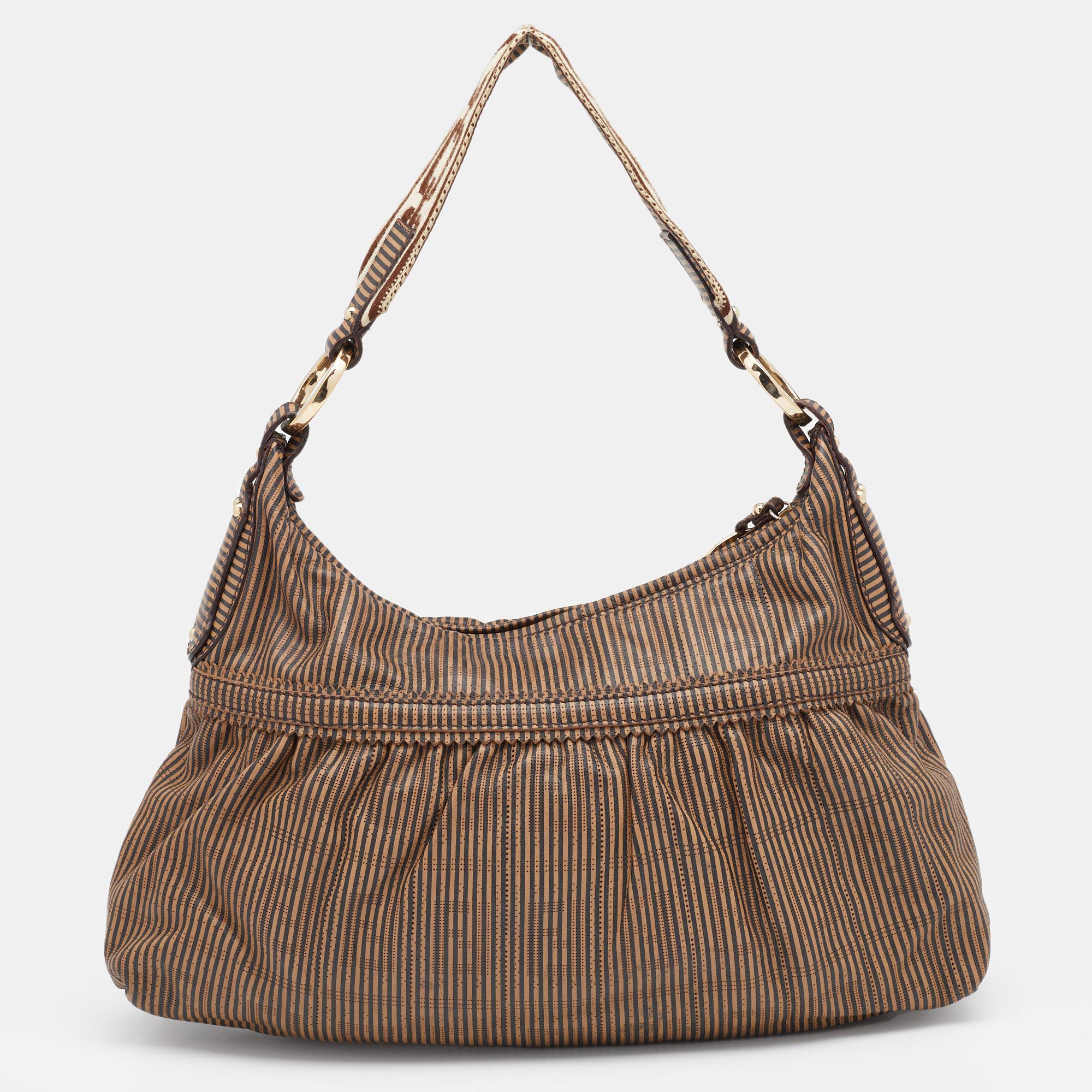 With pleat detailing, this Fendi Chef hobo has an attractive silhouette. Created from signature leather with perforations, it features a single top handle, stripe detailing, and a fabric-lined interior. The zipper closure at the top is equipped with
