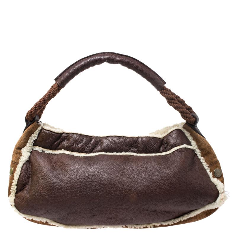 This hobo from Fendi is a pure style with its enticing features. Crafted from brown leather and suede, this hobo is held by a single handle and flaunt dual pockets on the front. The plush wool lining of the bag helps you accommodate all your