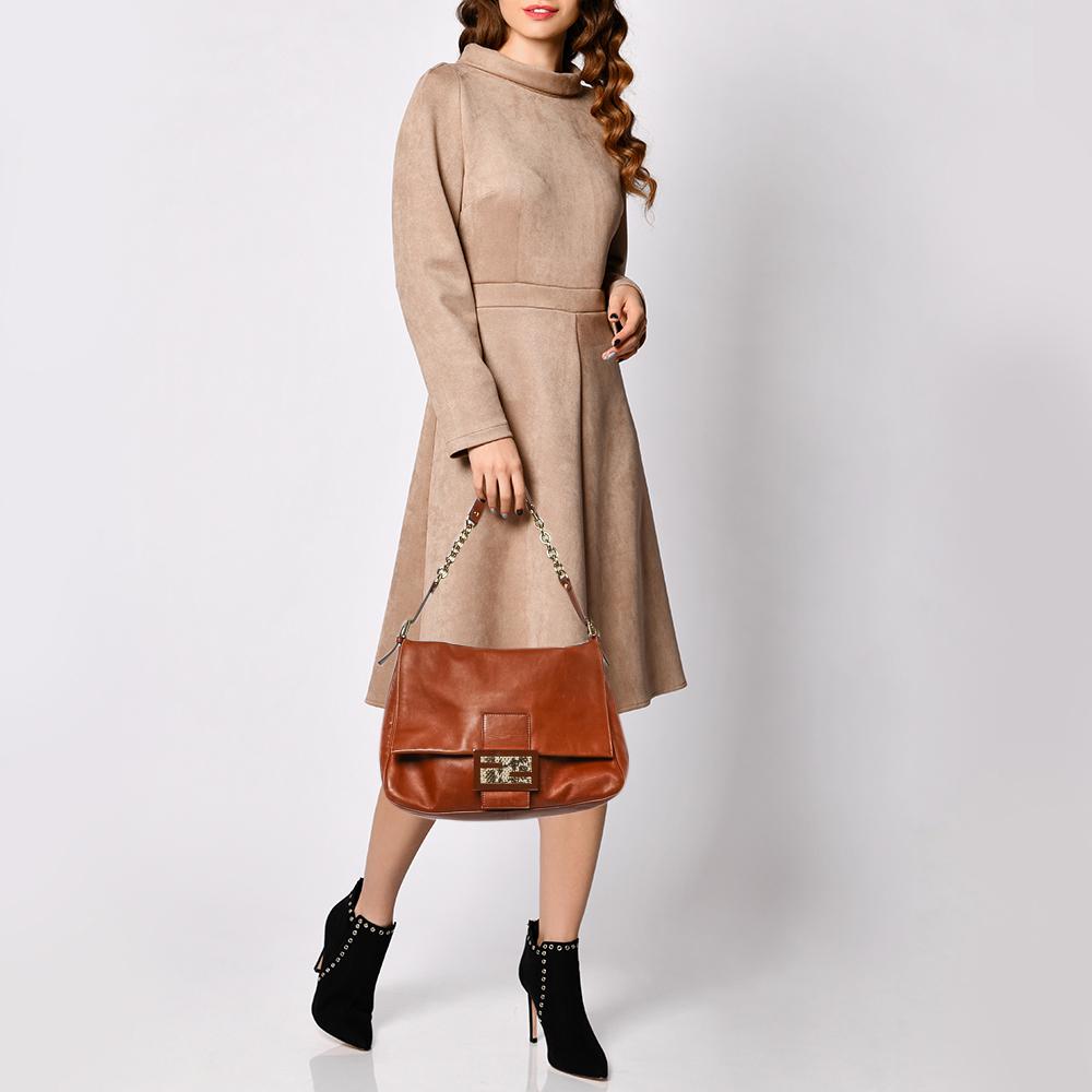 A combination of classy and casual, this Fendi bag will give your outfit a laid-back look. Crafted from leather, its brown color is matched with gold-tone hardware and a python leather Fendi plaque on the snap closure strap, adding an exotic design.