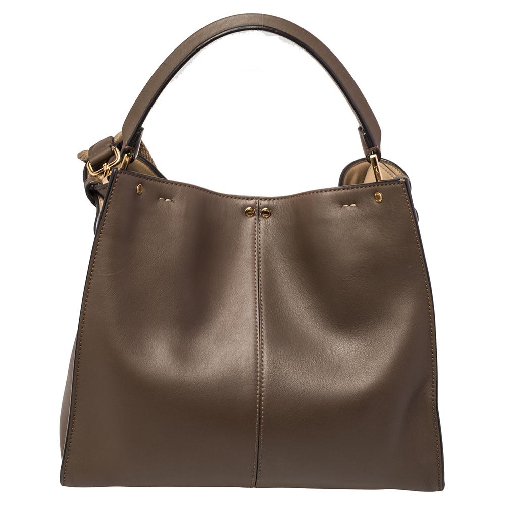 This exquisite Peekaboo X-Lite bag from Fendi is a great update of an iconic design. This version comes meticulously crafted from brown leather and is designed with a top handle for you to swing it in style. A twist-lock opens grandly into a