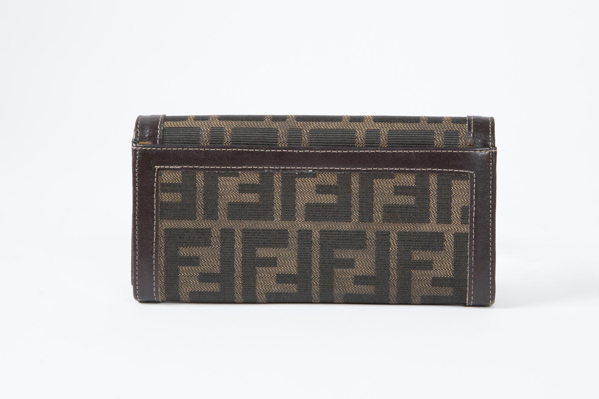 1980s Fendi brown and black canvas and leather monogram logo Zucca pattern wallet featuring an all over logo pattern, brown leather details, inside compartment, an inside gold tone logo stamp.  Circa 1980. 
Width 7in. (18cm)
Height closed 3.5in.