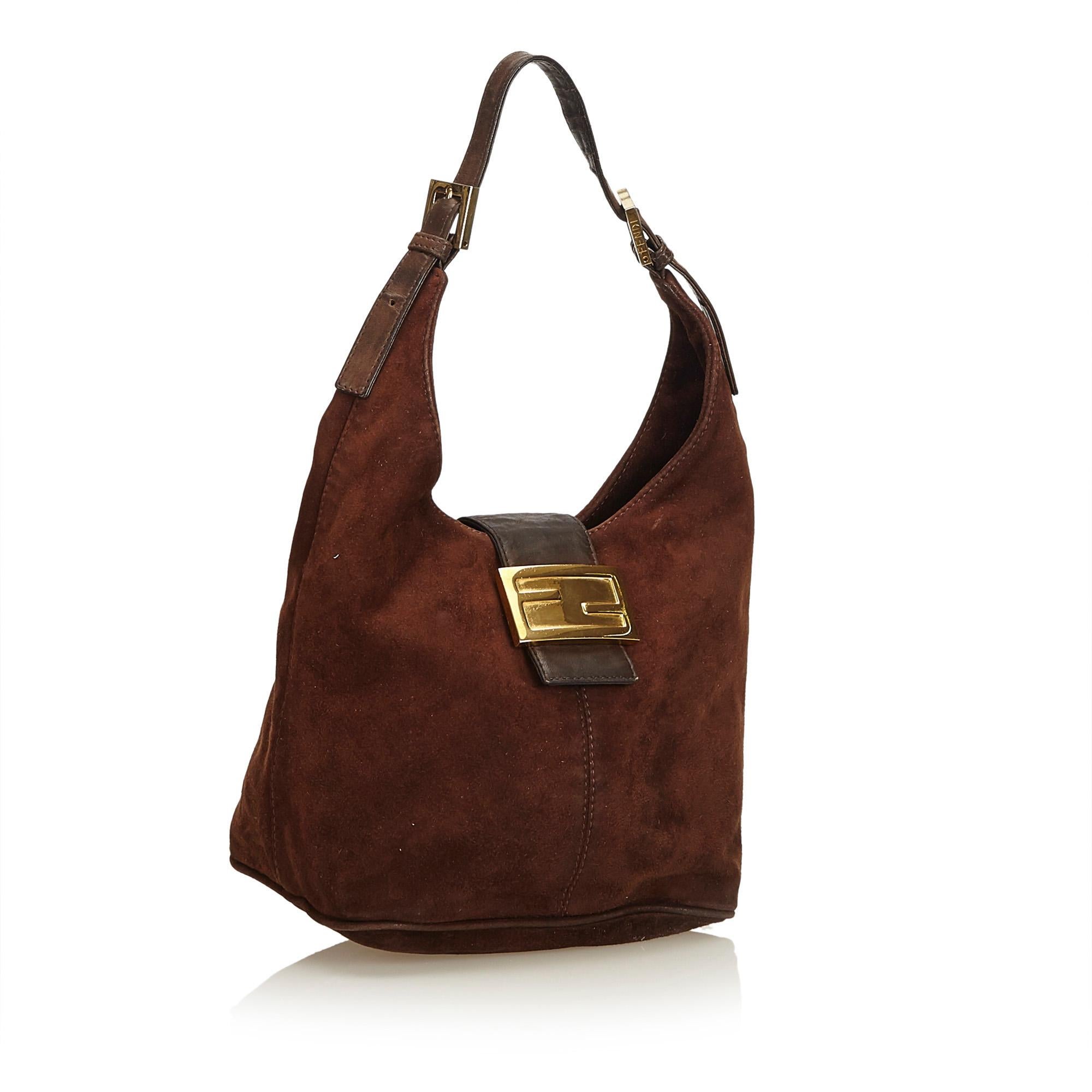 This hobo bag features a suede body with leather trim, flat leather strap, open top with flat leather strap and magnetic closure, and interior zip pocket. It carries as B+ condition rating.

Inclusions: 
This item does not come with