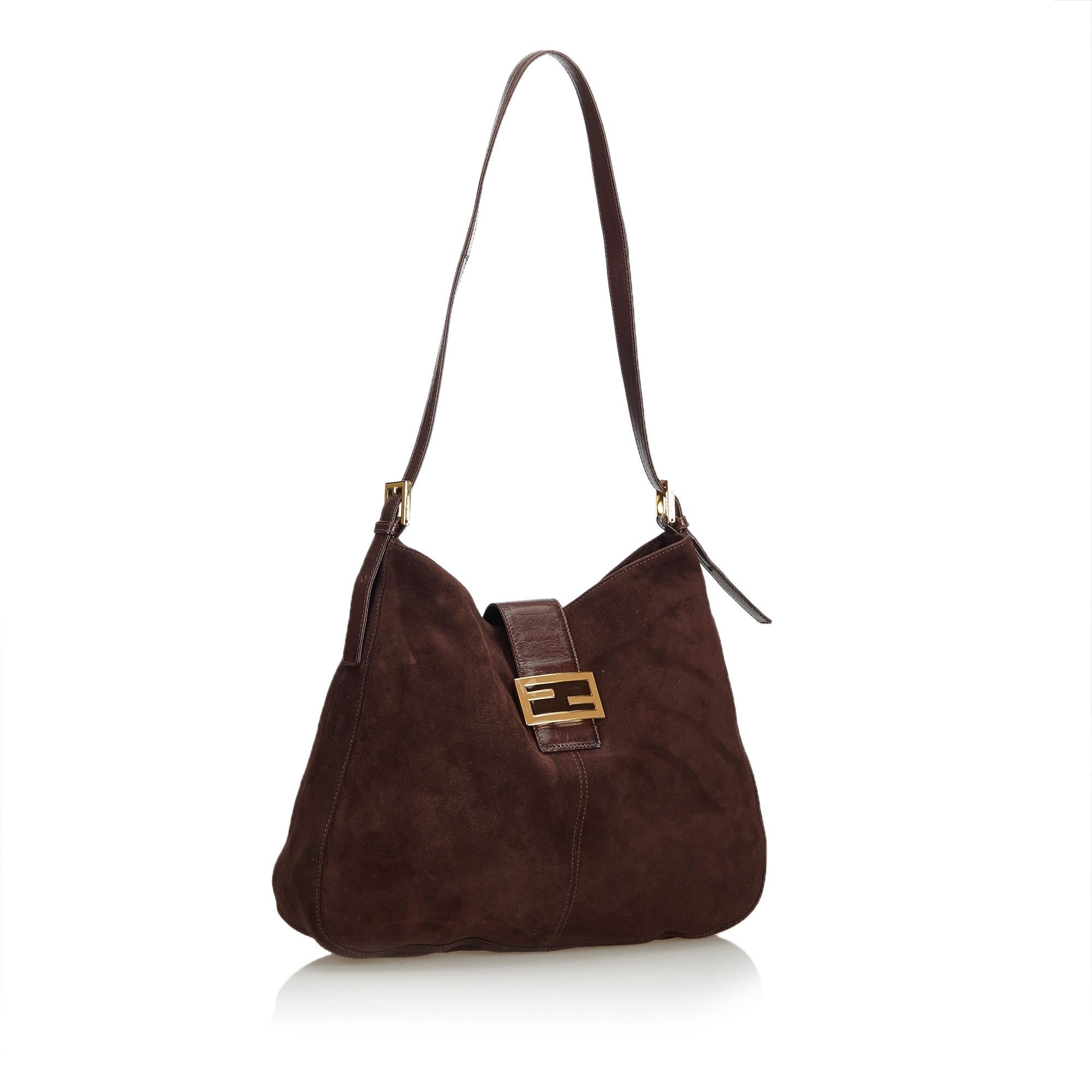 This shoulder bag features a suede body, flat leather strap, fold over top with flat leather strap and magnetic closure, and an interior zip pocket. It carries as B+ condition rating.

Inclusions: 
This item does not come with