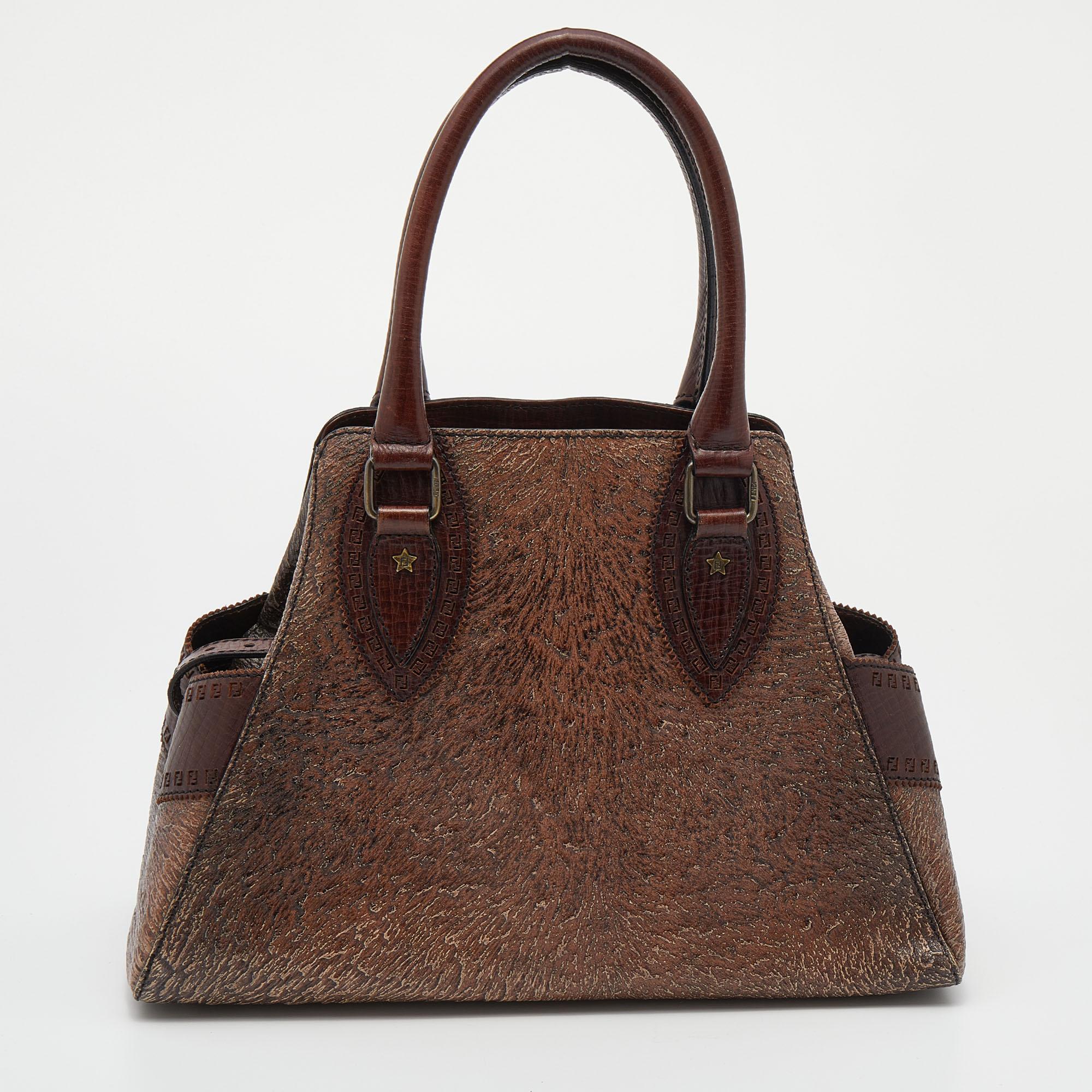 Fall in love almost instantly with this stunning bag by Fendi. Play with your style by carrying this brown bag that looks visually aesthetic. Shaped in textured embossed leather, this satchel is a trendy piece to add to your collection this