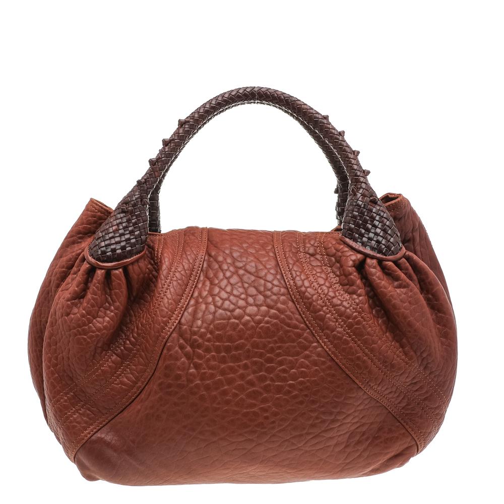 Be ready to seize the day with this edgy hobo from Fendi. Crafted from textured leather, the brown bag has unique braided handles and a front flap that reveals a capacious interior. Pair the super-stylish piece with coats and high heels.

Includes: 