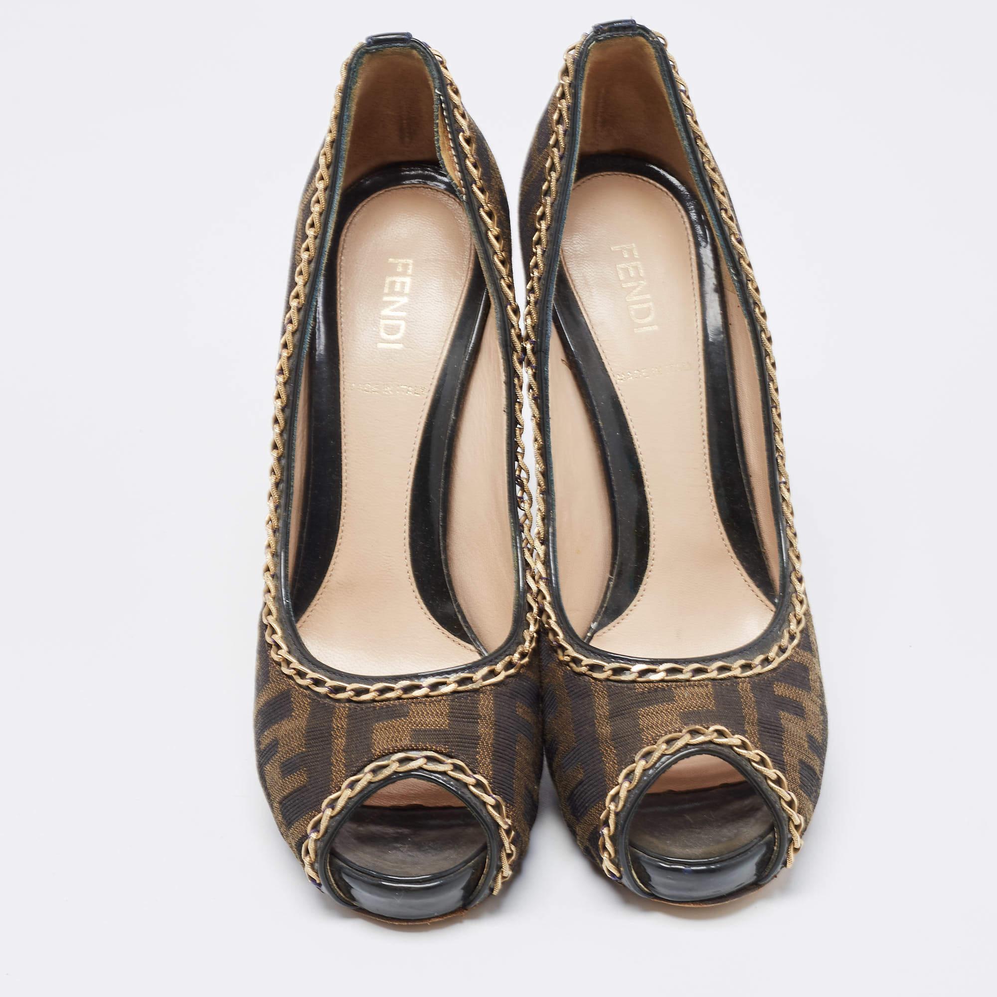 Make a style statement in true Fendi style with these gorgeous platform pumps! The women's pumps are crafted from Tobacco Zucca canvas and feature peep toes, chain embellishments, platforms, and 12.5cm heels.

