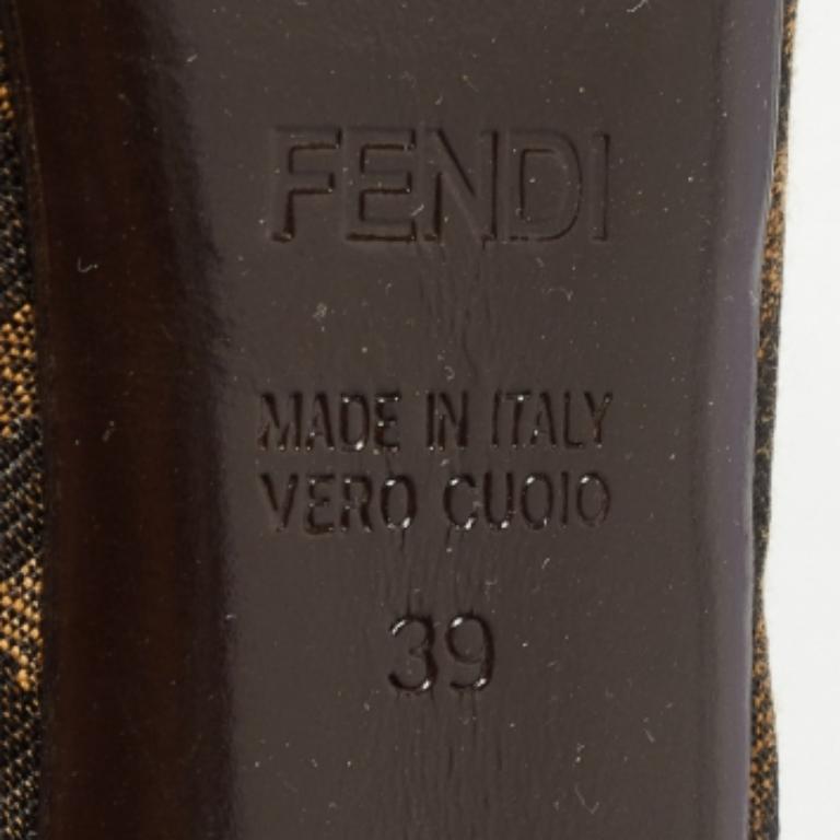 Estos zapatos de salón peep-toe de Fendi destacan la icónica lona Zucca en un intenso tono marrón, combinada con una cómoda suela de plataforma. El diseño atemporal se eleva con sutiles marcas y tacones de 12,5 cm junto con plataformas.