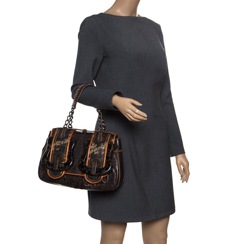 Fall in love instantly with this gorgeous bag by Fendi. Made from Zucca canvas, this piece will smoothly last you season after season. It has two handles, large buckle details and a well-sized fabric interior.

Includes: Info Booklet, Packaging
