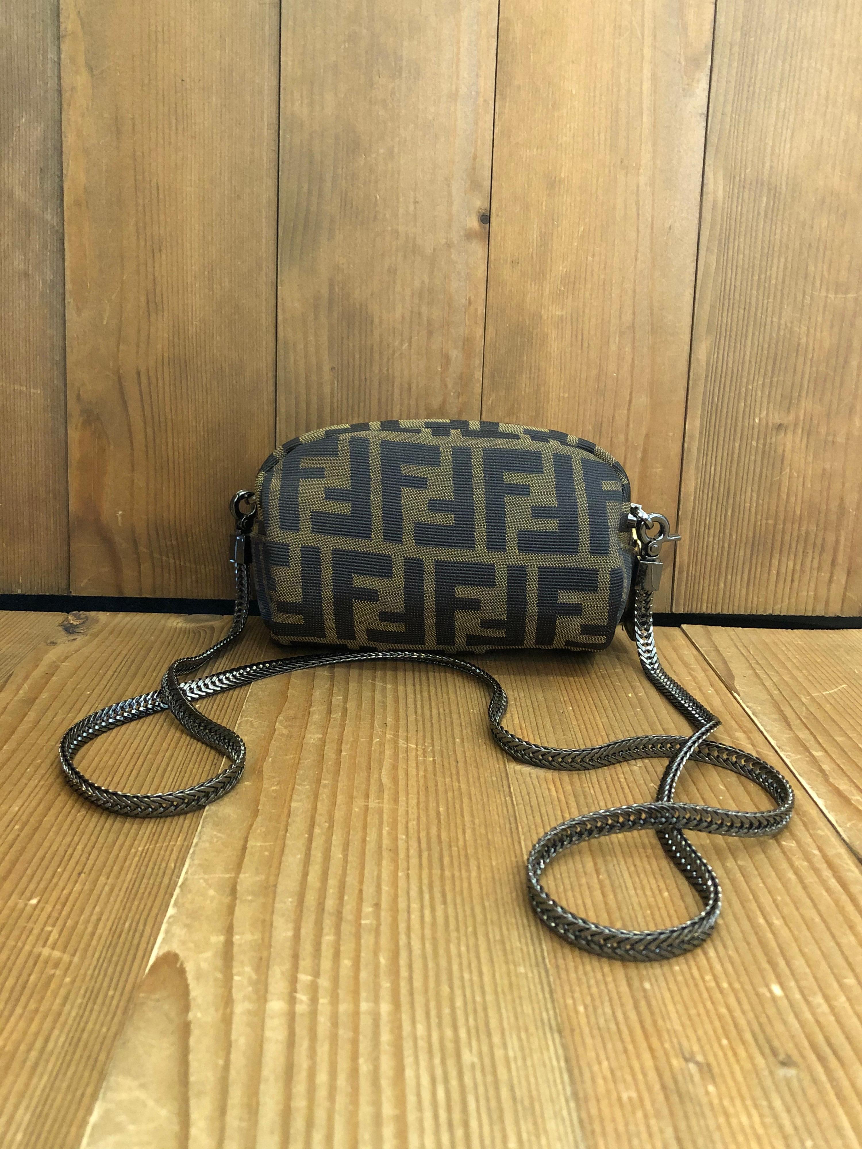 1990s Fendi cosmetic pouch in Fendi’s iconic FF Zucca jacquard. Made in Italy, Interior fully re-furnished. Third party clips and chain added to the pouch. 
Measures 5.75 x 3.5 x 2.75 inches (does NOT fit cell phone）

Condition： 
Outside: Minor