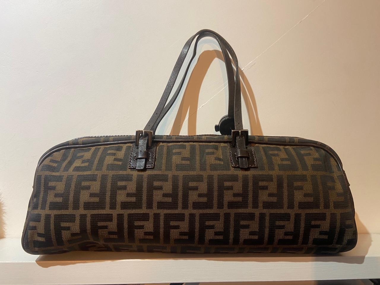 Vintage Fendi Brown Zucca Print Bowling bag Features the classic brown FF Monogram logo all over. Brown leather adjustable handle, back interior zip pocket and zip along the top seam for closure. In excellent vintage condition. 

Brand: Fendi
Color: