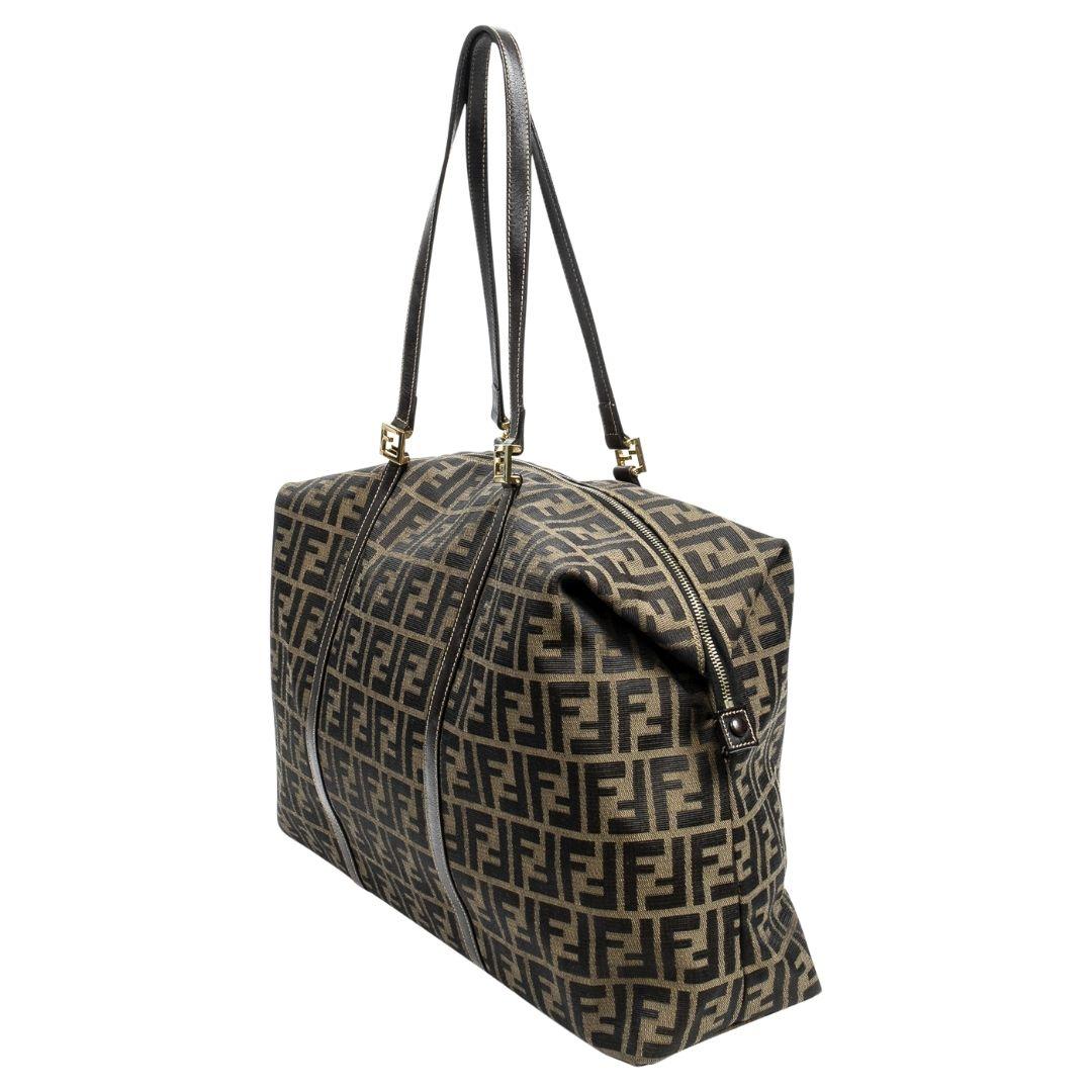 Fendi's iconic Zucca pattern adorns this brown canvas weekender bag. Gold-tone hardware and a zip closure complement the logo jacquard lining, featuring a zippered pocket for storage.

SPECIFICS
Length: 18.9