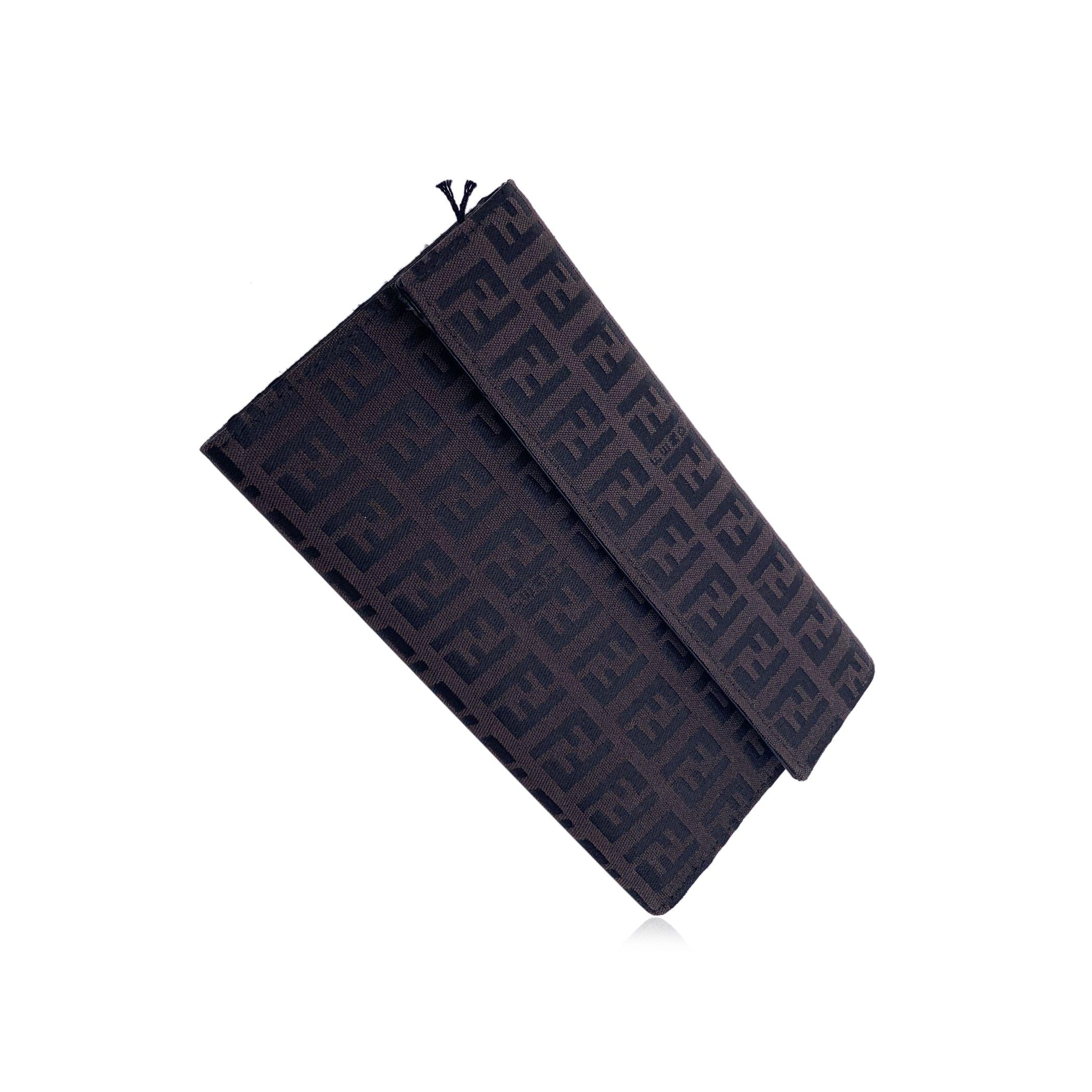 Fendi monogram wallet. Made of brown Zucchino monogram canvas, in brown and black colorsFlap with button closure. Inside it has 1 bill compartment, 1 compartment for coins, 4 open pockets and 1 slot with plastic window for documents. 'FENDI - Made