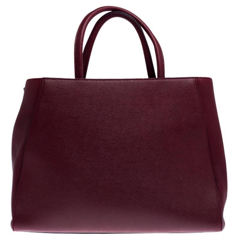 One of the most iconic designs from Fendi, 2jours continues to receive the love of women around the world. Crafted from burgundy leather, the bag features double rolled handles and a shoulder strap. It is also equipped with a fabric and suede