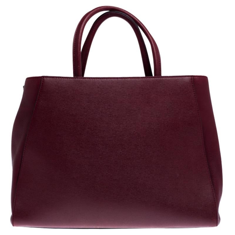 Uno dei modelli più iconici di Fendi, 2jours continua ad essere amato dalle donne di tutto il mondo. Realizzata in pelle bordeaux, la borsa presenta doppi manici arrotolati e una tracolla. È inoltre dotata di interni in tessuto e pelle scamosciata e