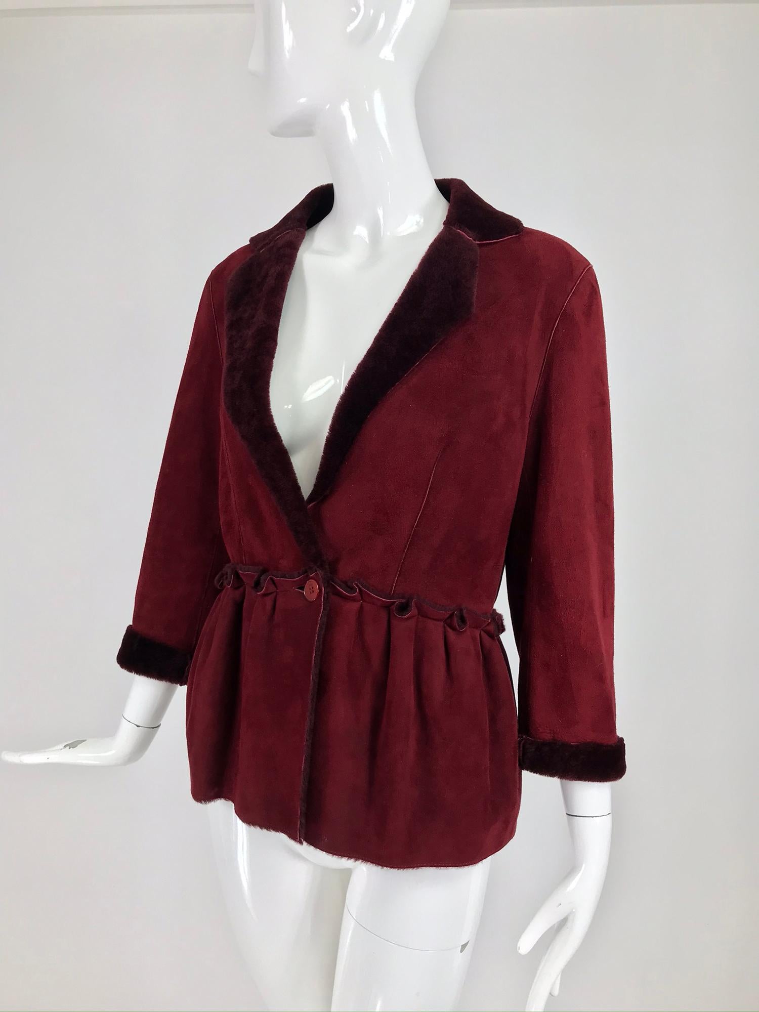 Fendi burgundy shearling button front jacket. Rich burgundy shearling is light and warm, this style could be worn as a layering piece. The jacket closes at the seamed waist front with a single button closure. The jacket  has notched lapels and a