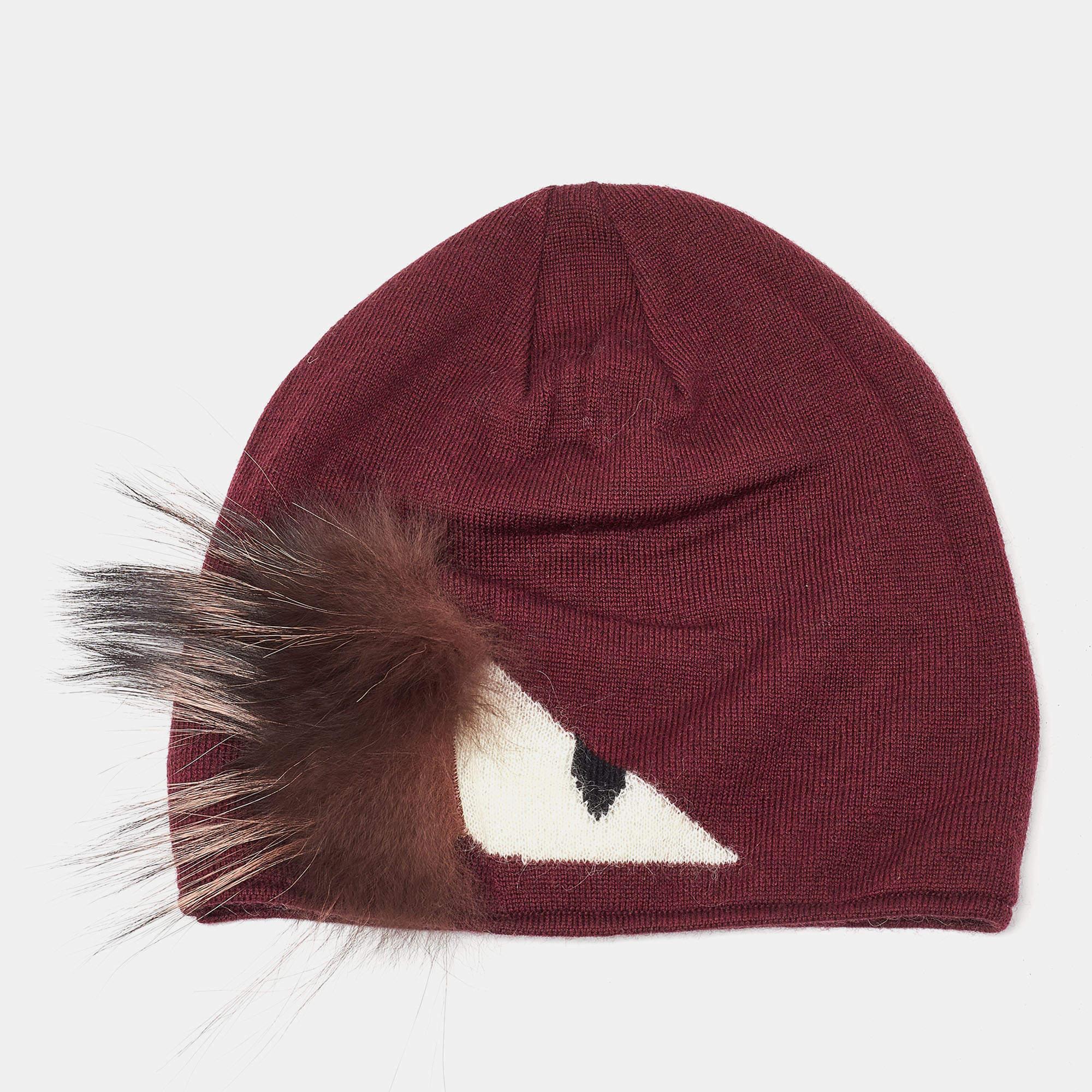 The Fendi beanie exudes luxury with its rich burgundy wool and playful Monster Eye fur embellishment. It combines warmth and style, making it a distinctive accessory for cold weather.

