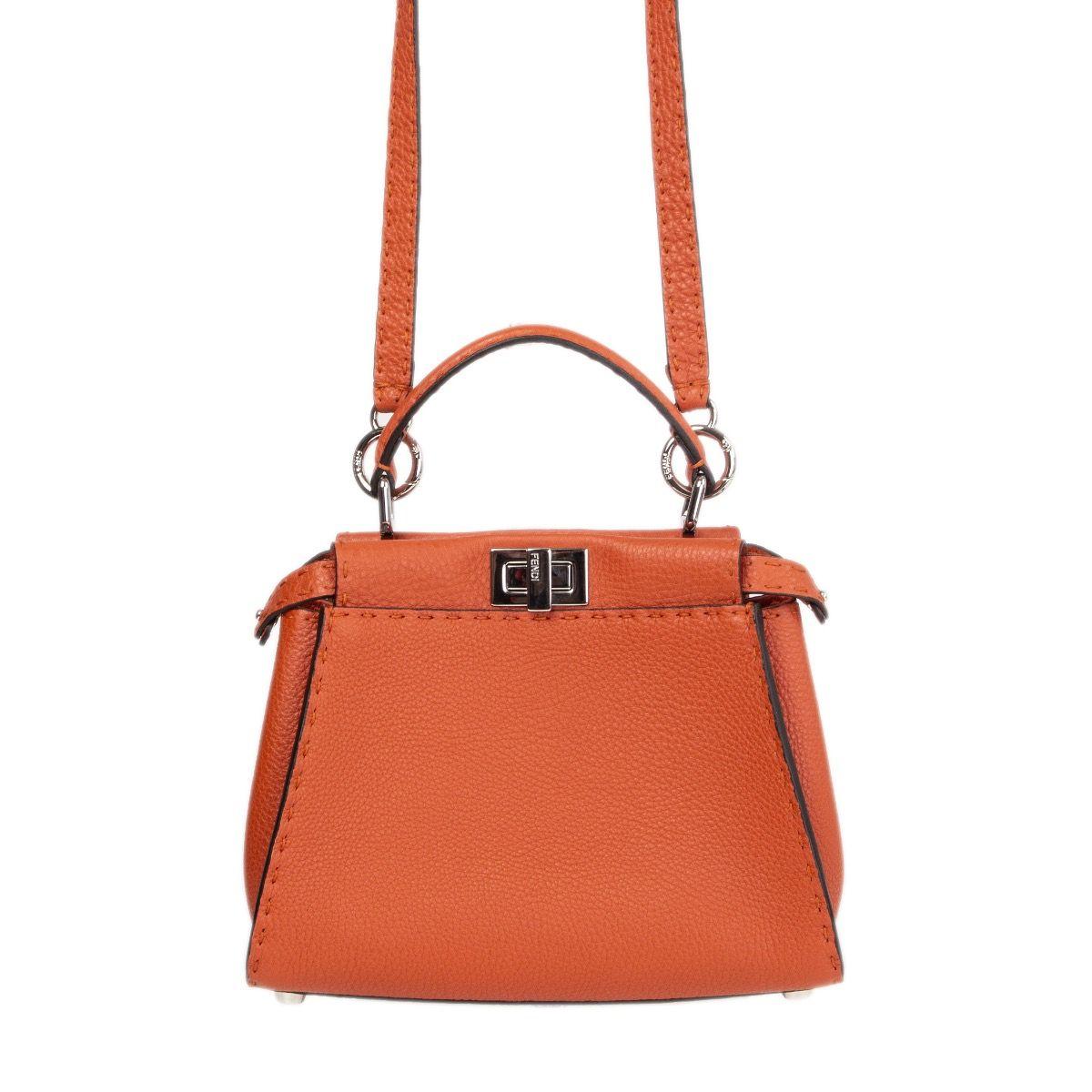 Fendi 'Peekaboo Mini' shoulder bag in burnt orange textured calfskin. Opens with a tdouble urn lock on top and is lined in burnt orange calfskin and brown microfibre with one zipper pocket and a credid card slot. Has been carried once and is in