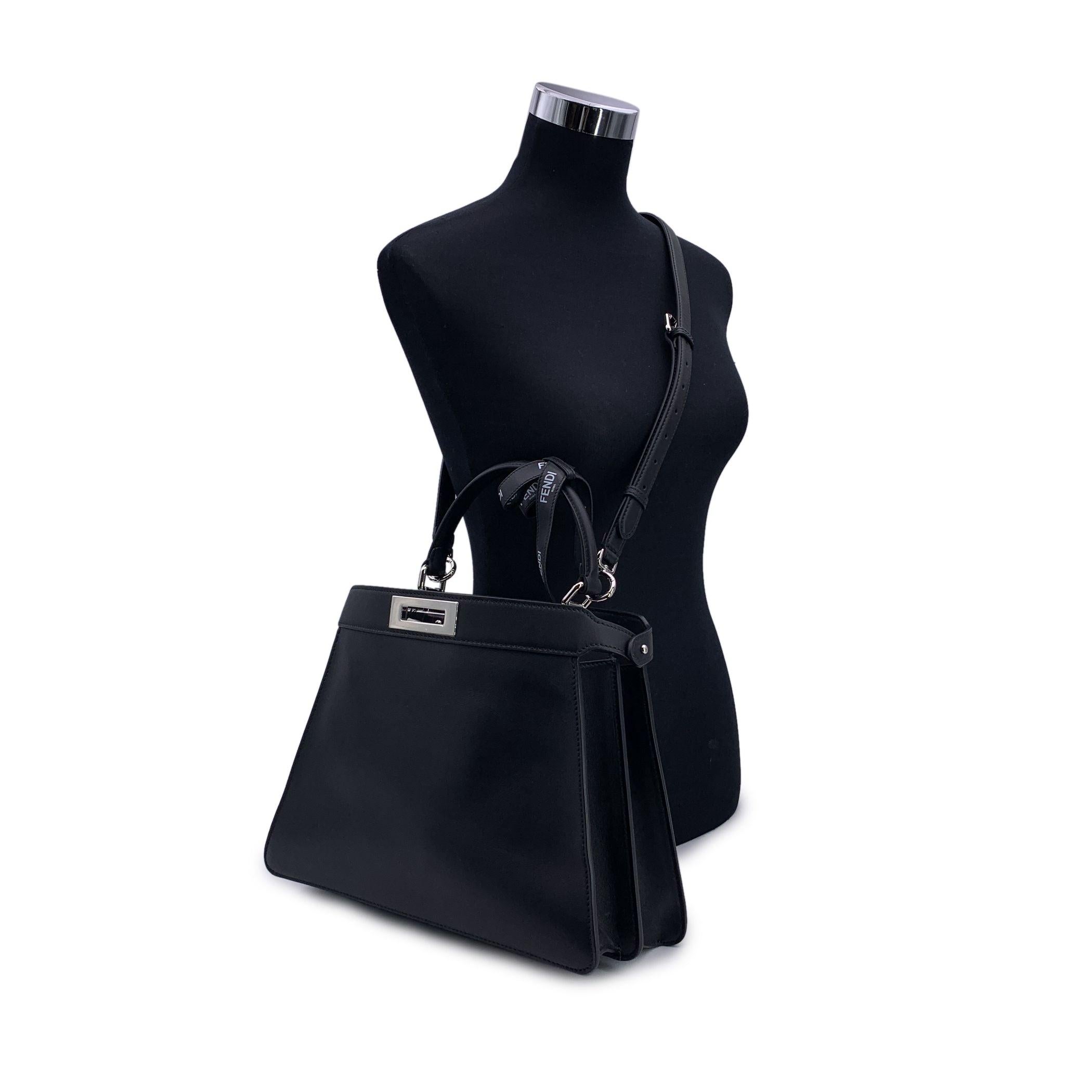This stunning Fendi by Marc Jacobs 'Medium Peekaboo ISeeU' bag in sleek black leather exudes elegance and sophistication. A modern classic, the bag is designed with two spacious compartments separated by a rigid partition, allowing for seamless