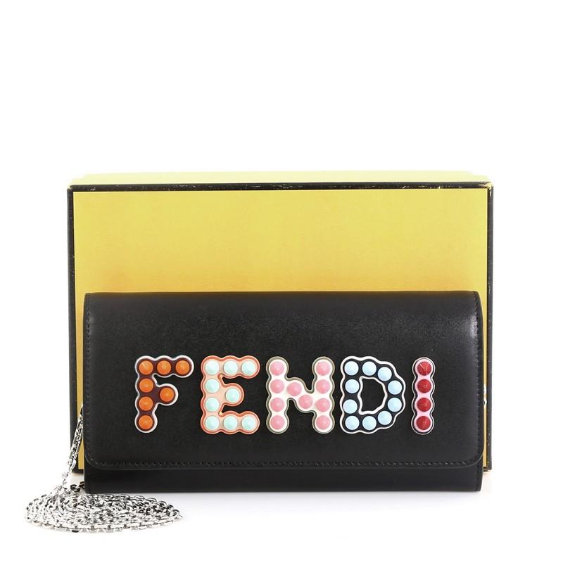 This Fendi By The Way Continental Chain Wallet Leather, crafted from black leather, features chain link strap, studded Fendi logo, and silver-tone hardware. Its flap opens to a black leather interior with multiple card slots and zip pocket.