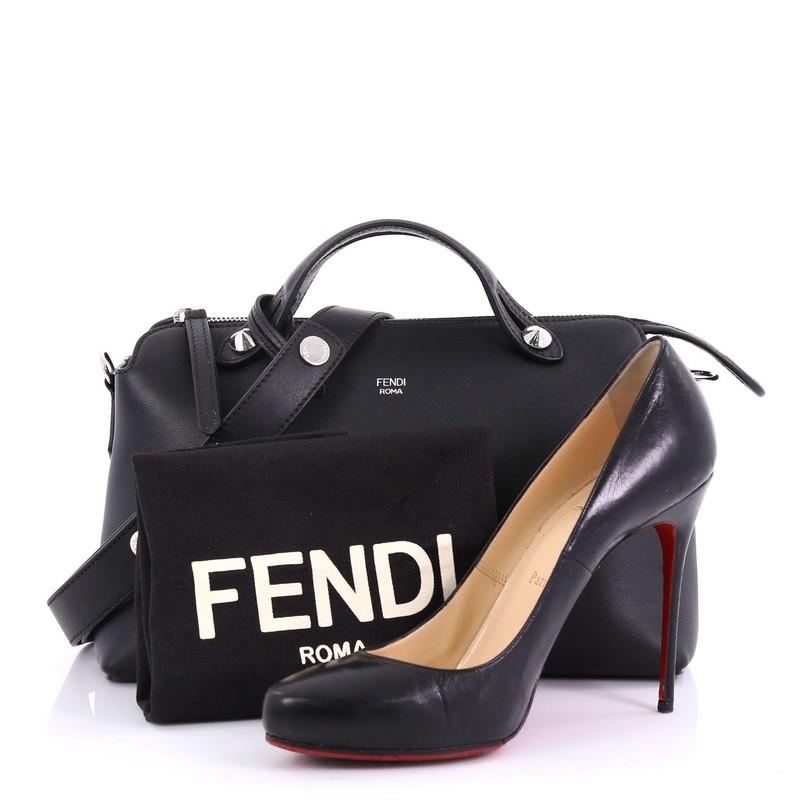 This Fendi By The Way Satchel Calfskin Small, crafted from black calfskin leather, features dual flat leather top handles, stamped Fendi foil logo, and silver-tone hardware. Its top zip closure opens to a black fabric interior with a center zip