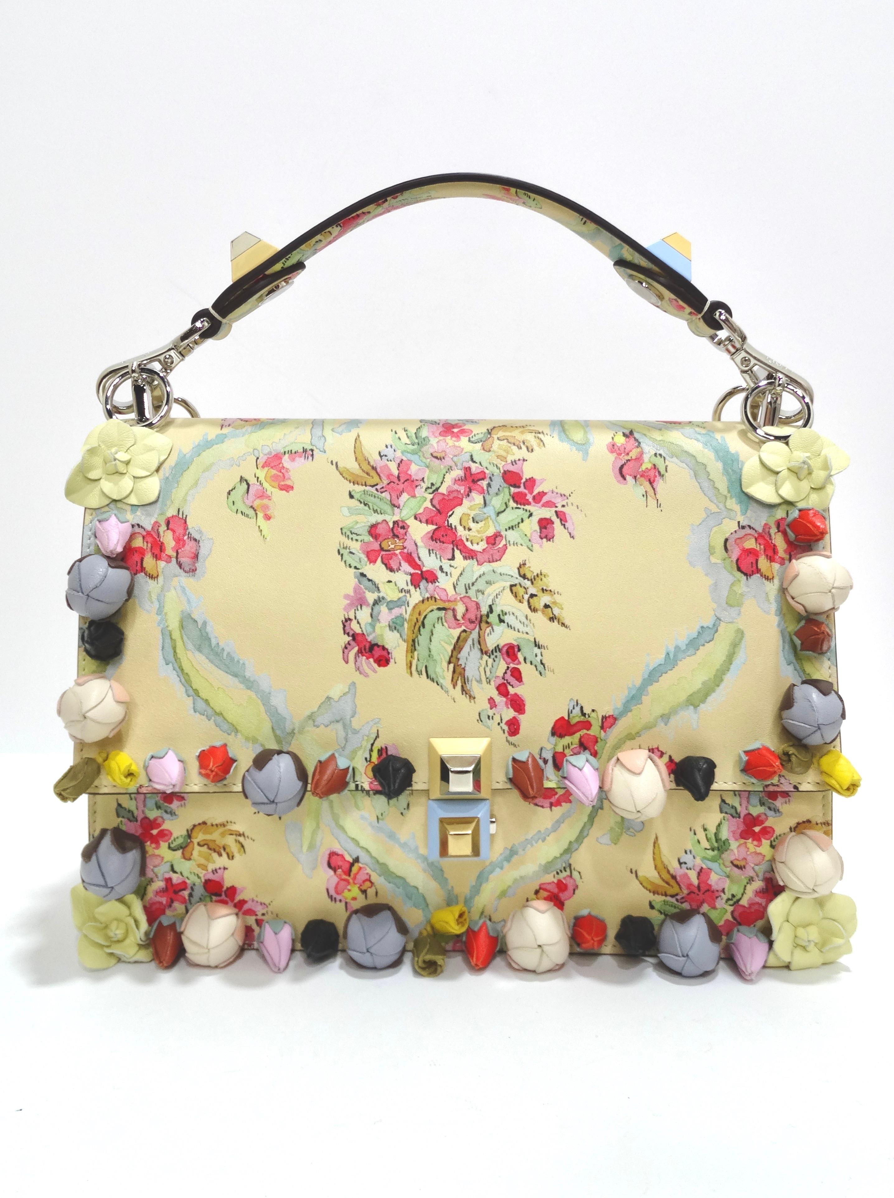 This Fendi bag is crafted of smooth calfskin leather in cream and floral-print leather with floral appliqués and signature pyramid studs at the removable top handle and front flap closure. Comes with a crossbody strap as well. The bag opens to a