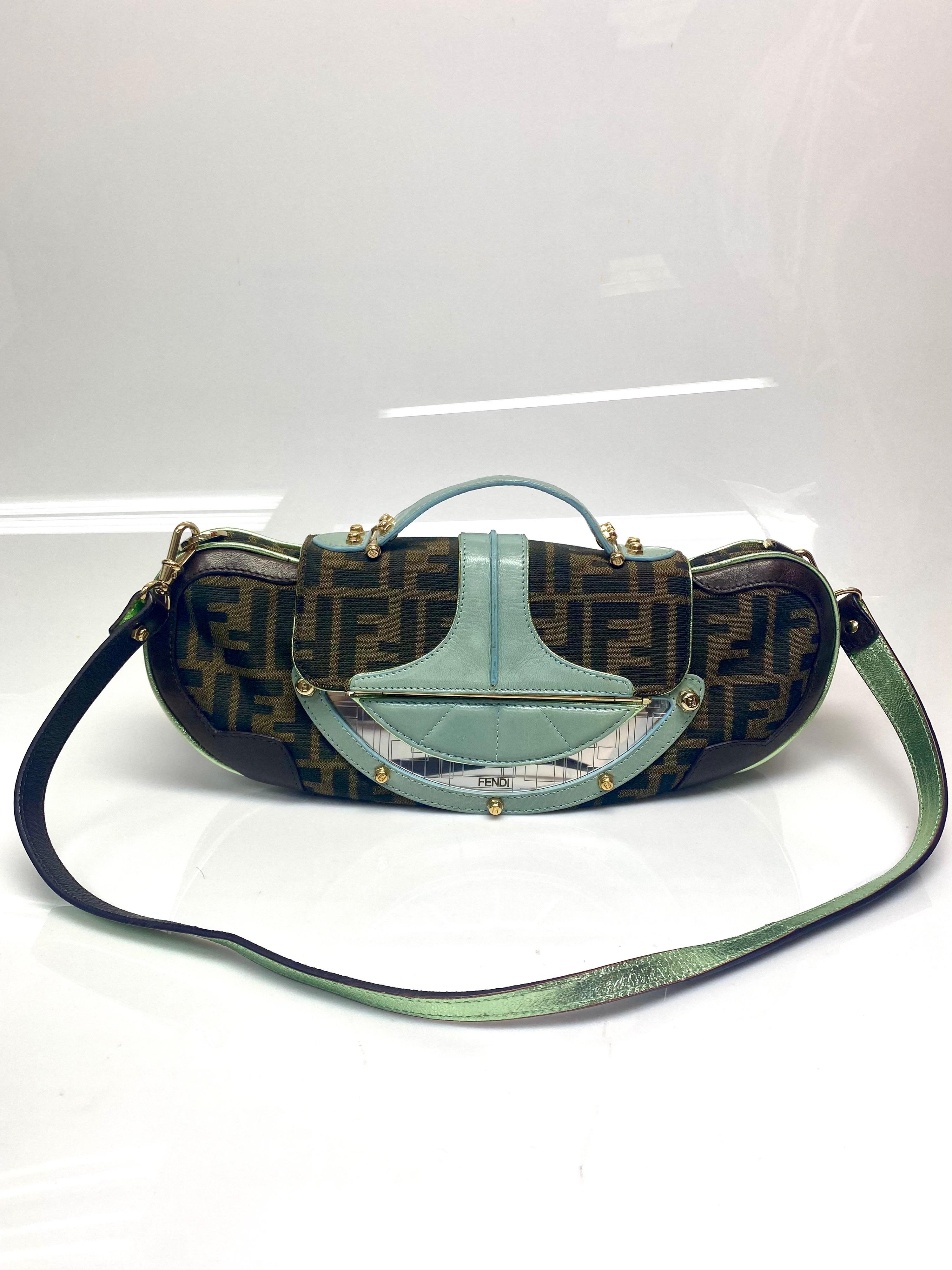 Fendi Canvas Vanity Mirror Clutch Handbag. This beautiful eccentric bag from Fendi is a classic piece with a twist. Featuring the Fendi canvas and hues of Aqua and browns. The bag can be used as a clutch or a handbag with the removable/reversable