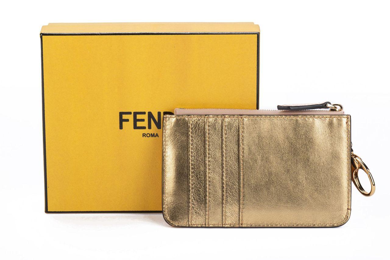 Fendi Key case pouch cuoio roma in powder pink. The item is crafted of leather and has a golden clasp so it can be attached to a bag. It is new and comes with a box, dustcover, booklet and tag