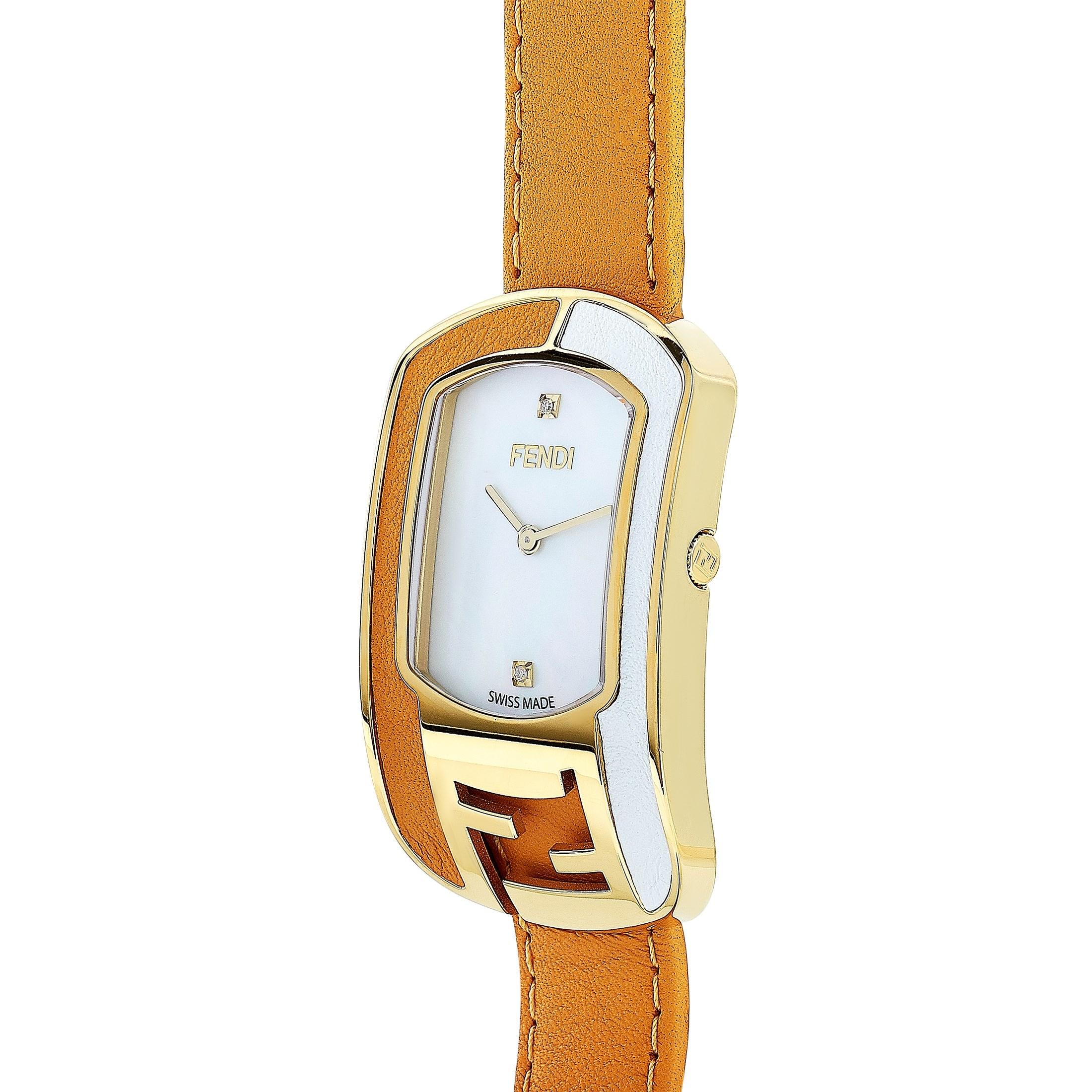 This is the Fendi Chameleon watch, reference number F334434551D1.

It is presented with a gold-tone stainless steel case that is embellished with tan and white leather inserts and offers water resistance of 30 meters. The watch is worn on a tan