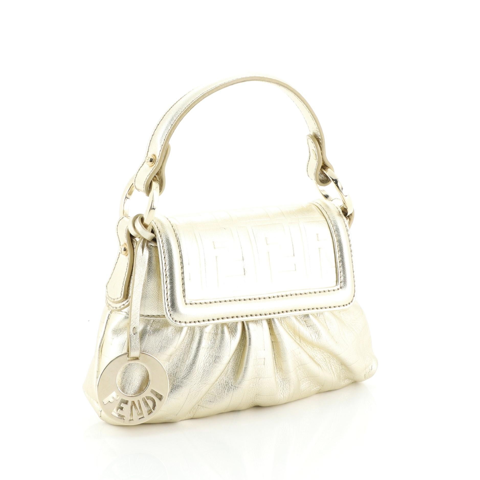 This Fendi Chef Handle Bag Zucca Embossed Leather Mini, crafted from gold leather, features a top handle, pleated detailing and gold-tone hardware. Its zip closure opens to a neutral fabric interior. 

Estimated Retail Price: $750
Condition: Very