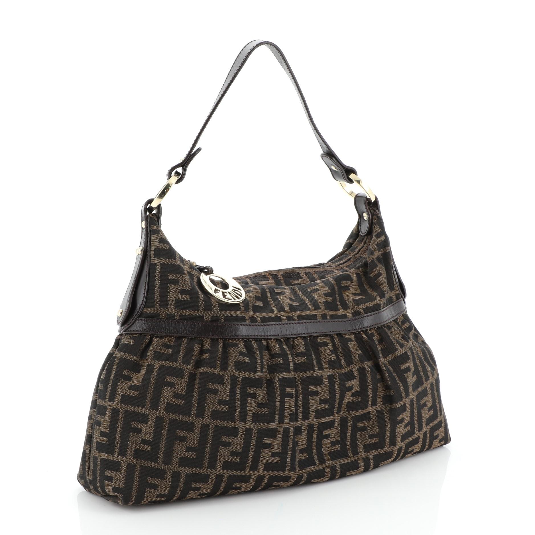 This Fendi Chef Hobo Zucca Canvas Large, crafted from brown zucca canvas, features leather top handle and gold-tone hardware. Its zip closure opens to a brown fabric interior with zip pocket. 

Condition: Great. Odor in interior. Light wear on