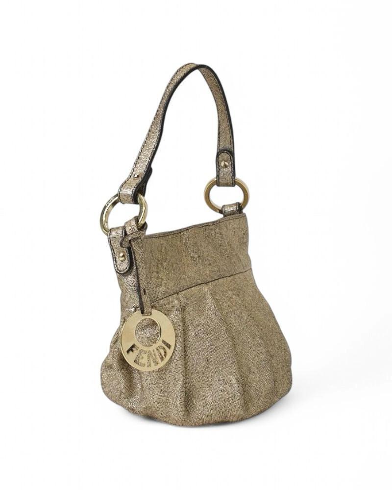 Fendi signature bag, Chef model in Mini size, made of gold laminated fabric with gold gardware. Equipped with an interior magnetic button closure and internally lined in black canvas, the bag is roomy for essentials. Equipped with a handle for