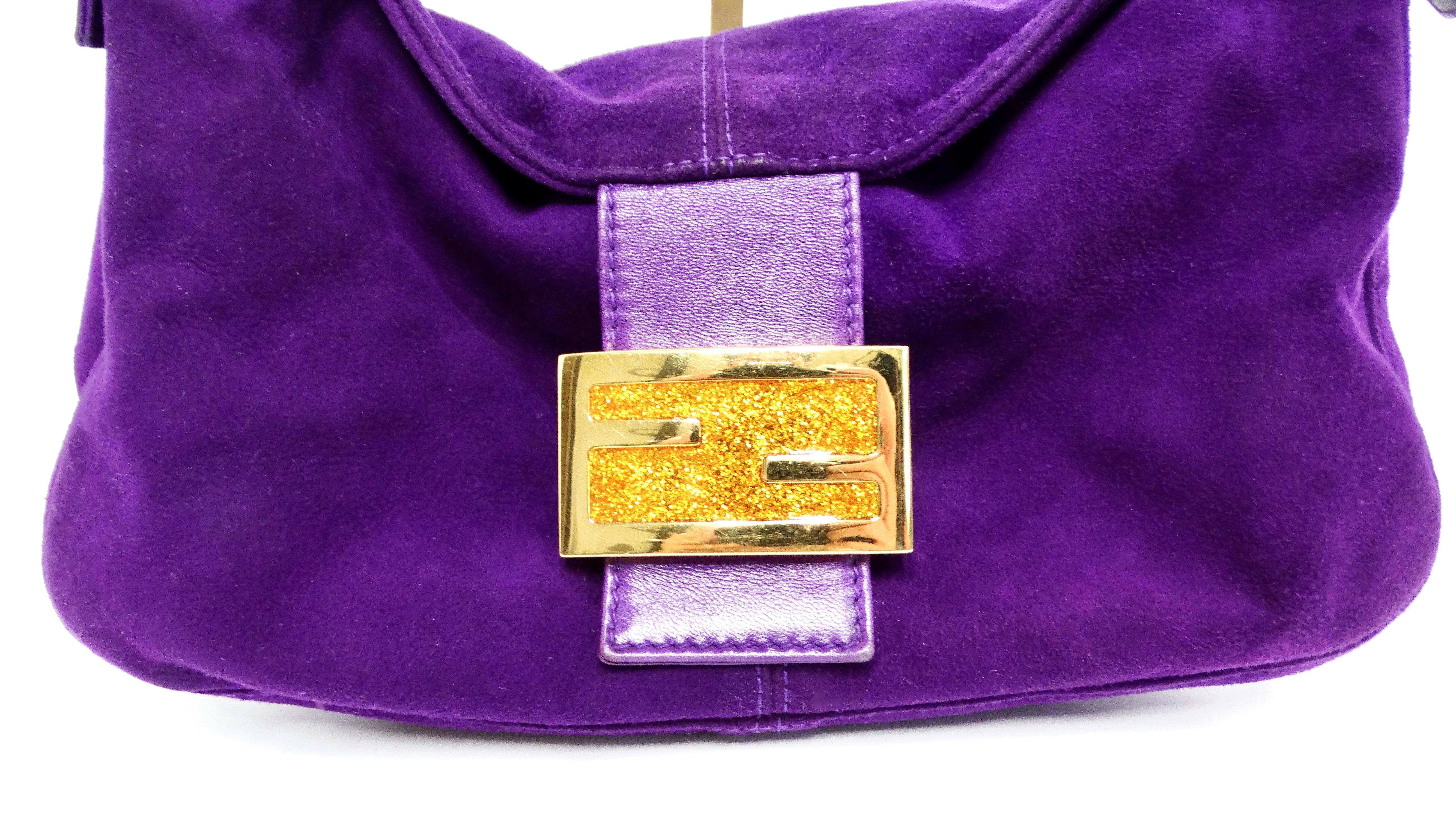 The Fendi Circa 1990s Purple Suede & Gold-Tone Baguette Shoulder Bag is a stunning example of luxury craftsmanship and timeless style. This bag epitomizes the elegance of the '90s-early 2000s fashion scene with its eye-catching rich purple suede