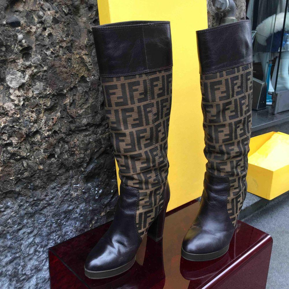 Fendi Cloth Boots in Brown

Fendi monogram boot 
In brown leather with FF logoed fabric inserts. 
Size 36.5. The heel measures 9.5 cm, the platform 2 cm, the boot 45 cm. 
Includes original box. 
Good condition, with only small signs of