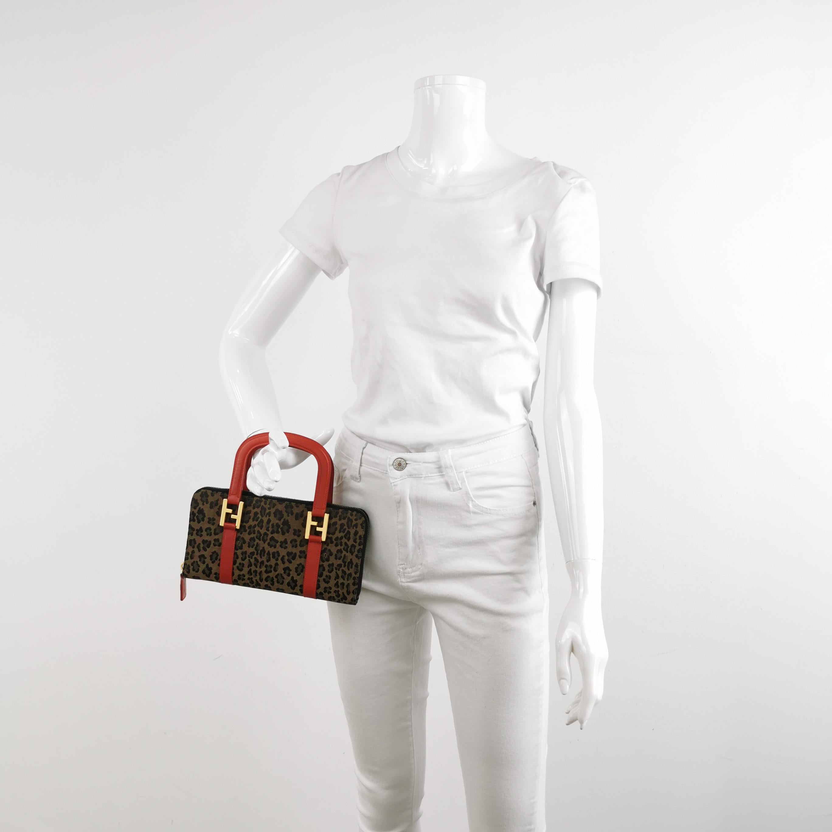 Pochette Fendi in denim con stampa leopardo e manici in pelle rossa
Queste sono foto professionali della borsa offerta da Luxbags.
Questa rara Baguette di Fendi combina una selvaggia stampa leopardata, un'audace pelle rossa e hardware in tonalità