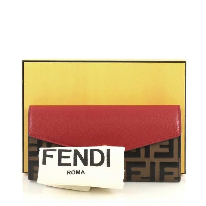 This Fendi Continental Envelope Wallet Leather and Logo Embossed Leather, crafted from red leather and brown logo embossed leather, features gold-tone hardware. Its press stud closure opens to a red leather interior with gusseted compartments, zip