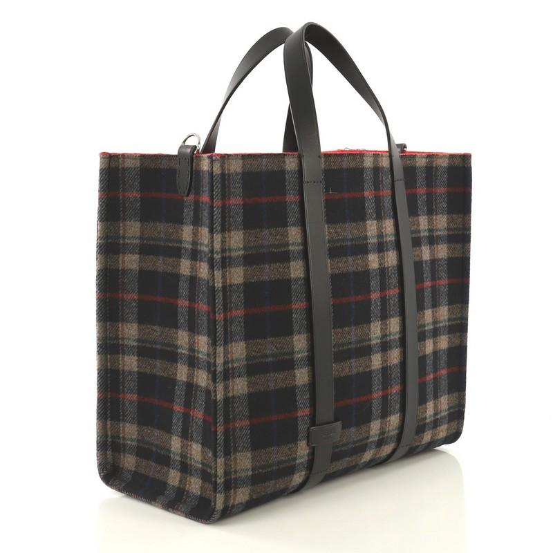 This Fendi Convertible Open Tote Tartan Wool and Leather Large, crafted from multicolor wool and leather, features dual flat leather handles and silver-tone hardware. It opens to a red wool interior with side zip pocket. 

Estimated Retail Price: