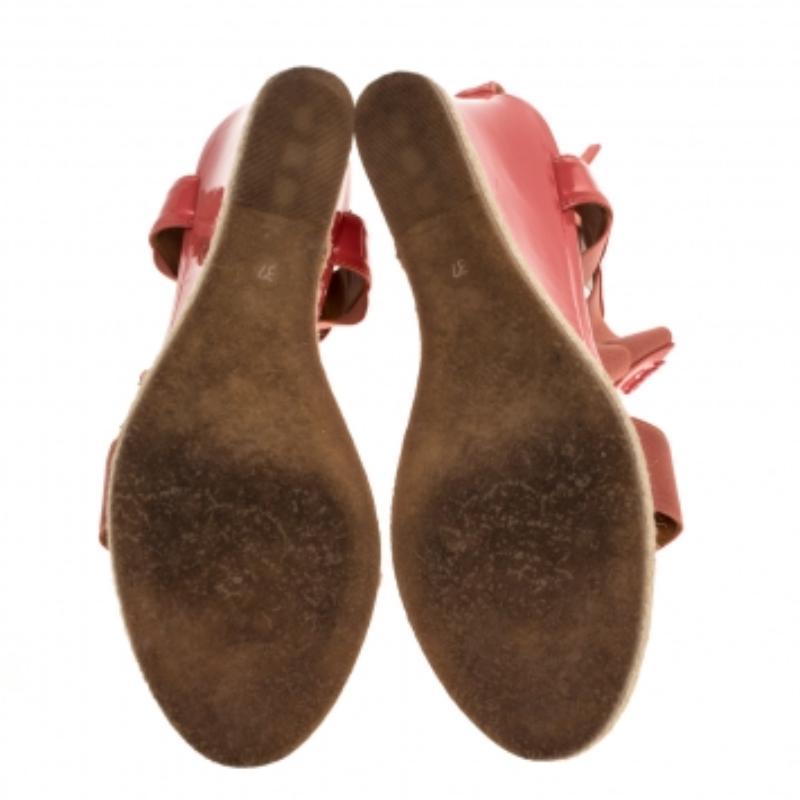 Fendi made these sandals to crown your feet with beauty. They are constructed with elastic straps at the front and ankles, a patent leather strap forming the T and zippers on the counters. Gold-tone logo accents on the uppers and wedge heels make