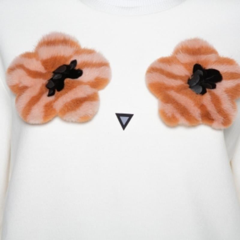 This Fendi jumper is a feminine creation that can be paired with a lot of bottoms. Crafted from quality materials, this cream jumper comes with pom-pom appliques on the front. It has long, flared sleeves, a simple neckline, and a zip fastening.