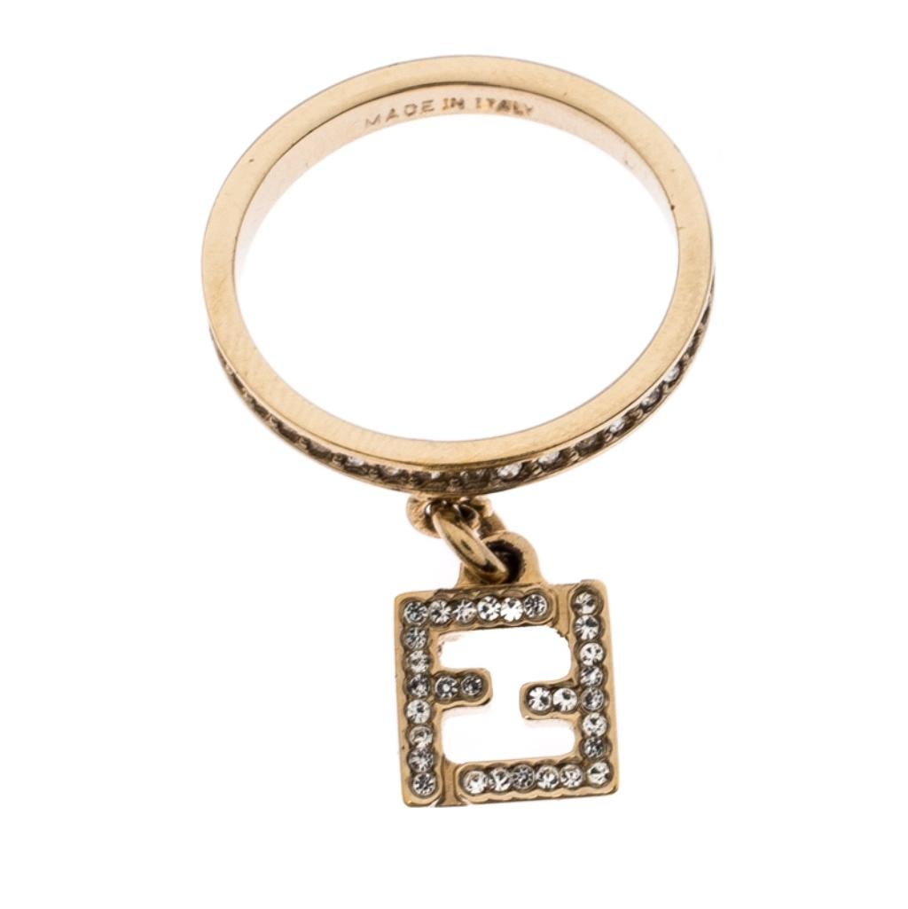 This Fendi ring is designed to be flaunted. It has been crafted from gold-tone metal and carry a modern design of an embellished band with a charm of crystal-decorated FF logo dangling from it. This piece will make a fine addition to your jewelry