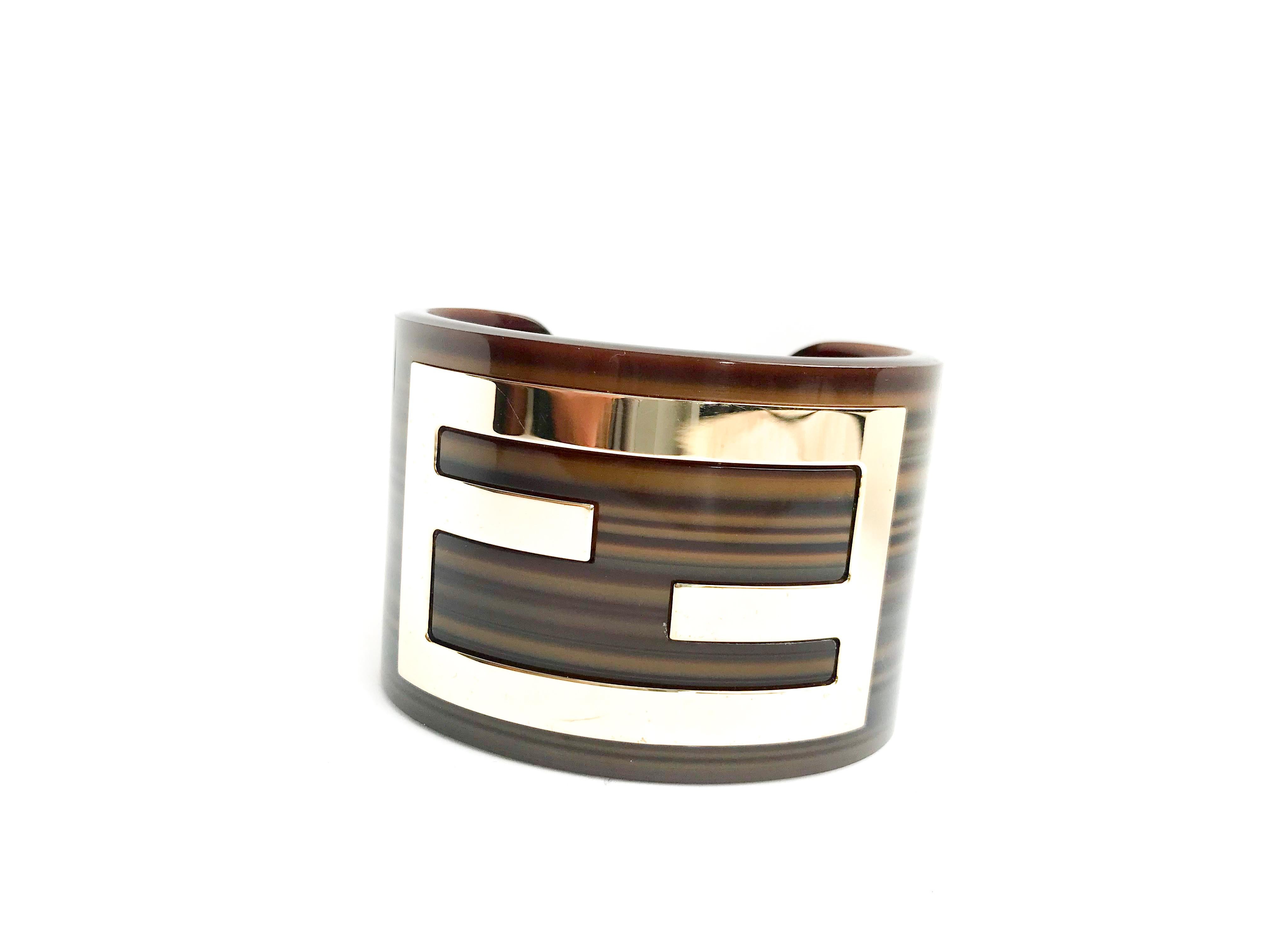 Fendi Cuff Bracelet. Made of an beautiful deep oak brown acrylic with metal Fendi logo inlaid.  Signed Fendi Made in Italy inside the bracelet.

Comes with dustbag.