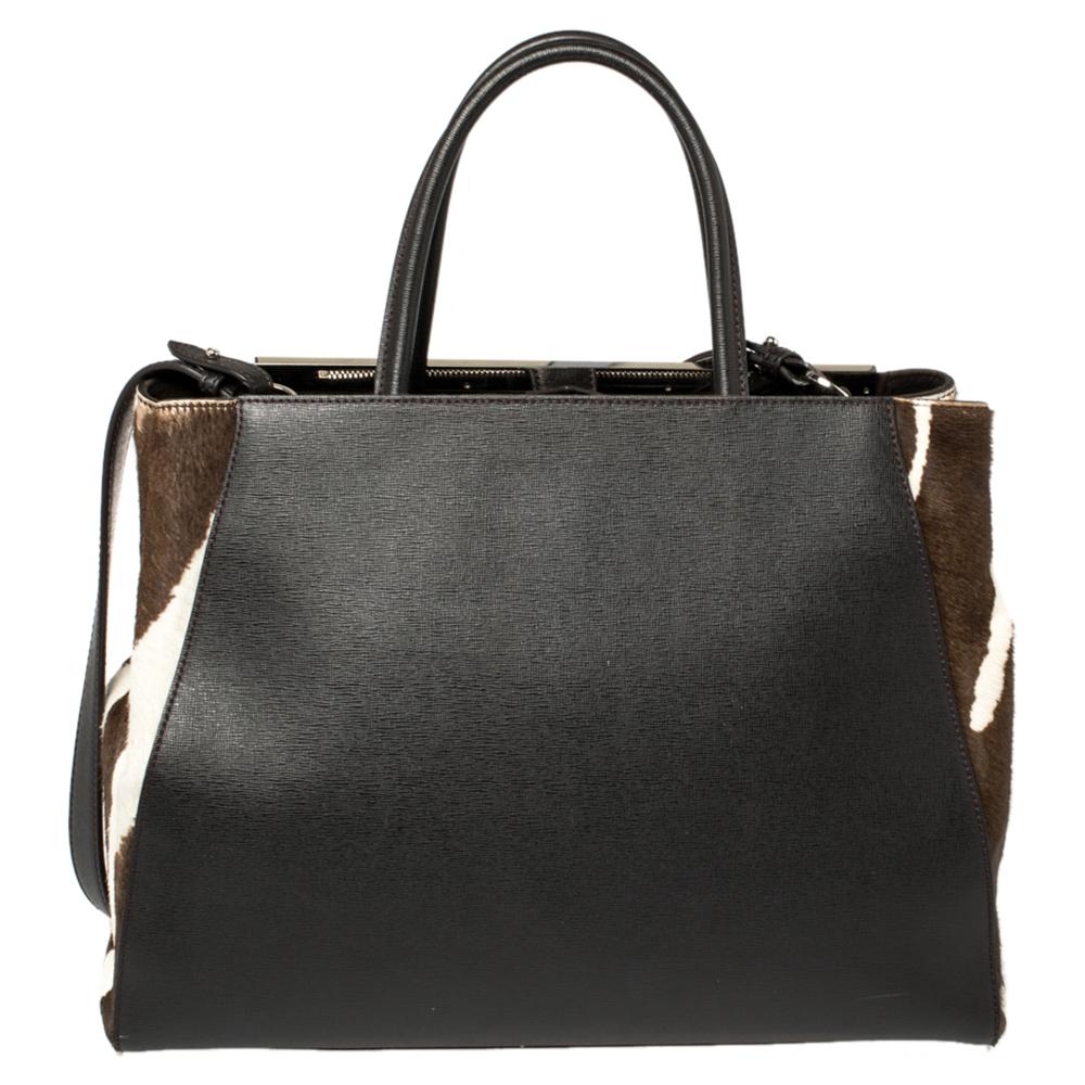 Fendi's 2Jours tote is an iconic design. Crafted from leather in a dark brown hue, the bag features a logo bar at the topline, calf hair panels on the sides, and can be carried with double rolled handles or a shoulder strap. A button closure opens