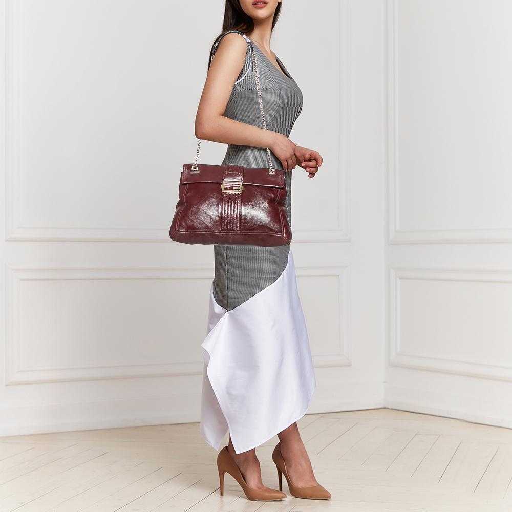 A flap bag in dark red leather highlighted by the FF symbol on the front, this bag is held by a shoulder handle and lined with fabric. It is a fine mix of quality and classic appeal. Add a touch of Fendi's timeless charm to your look with this Maxi