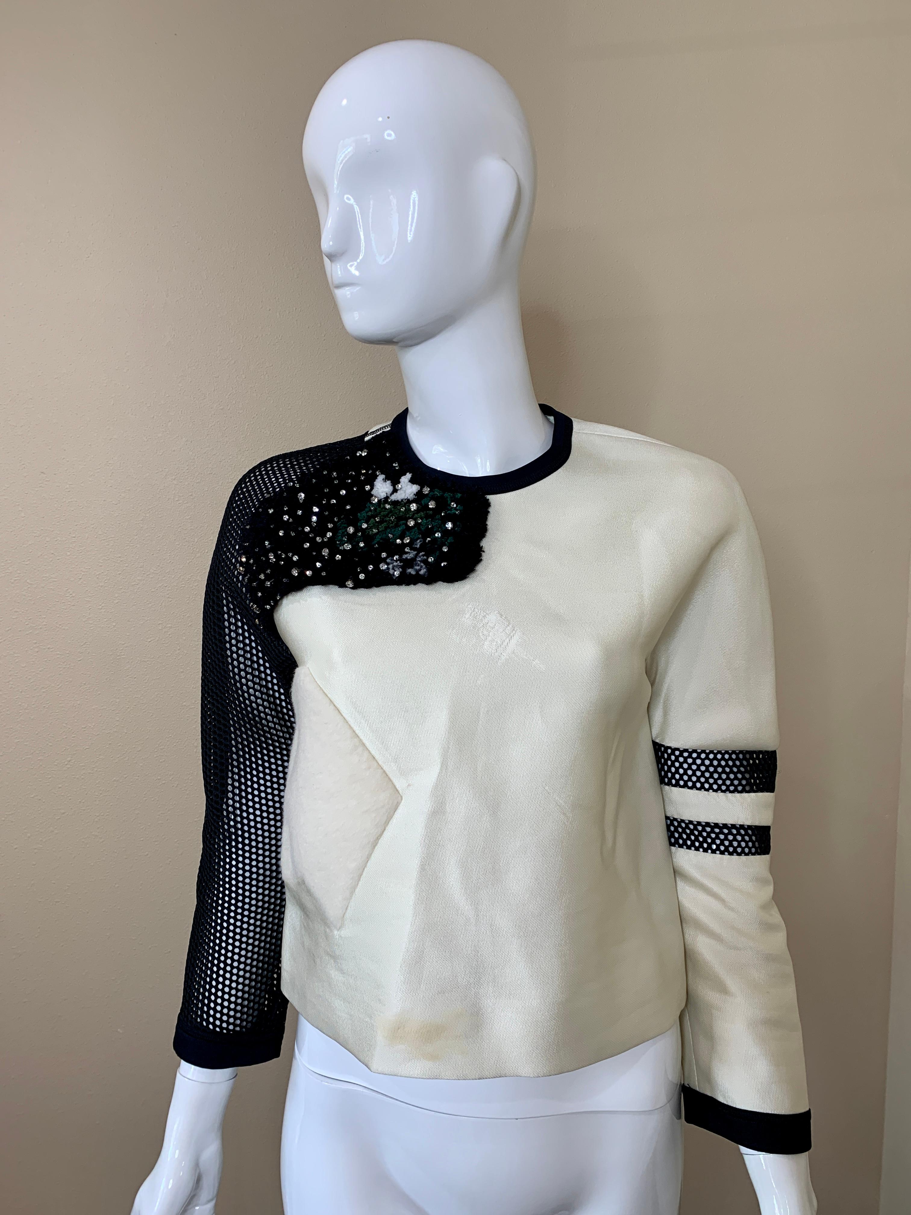 Very Unique and beutiful Fendi Sweater. It is a mixture of colors and textures - cream, black and turquoise with different textures throughout the piece. 

Zipper closure in back for easy pull-on wear. Size 36 with not a lot of give because of the