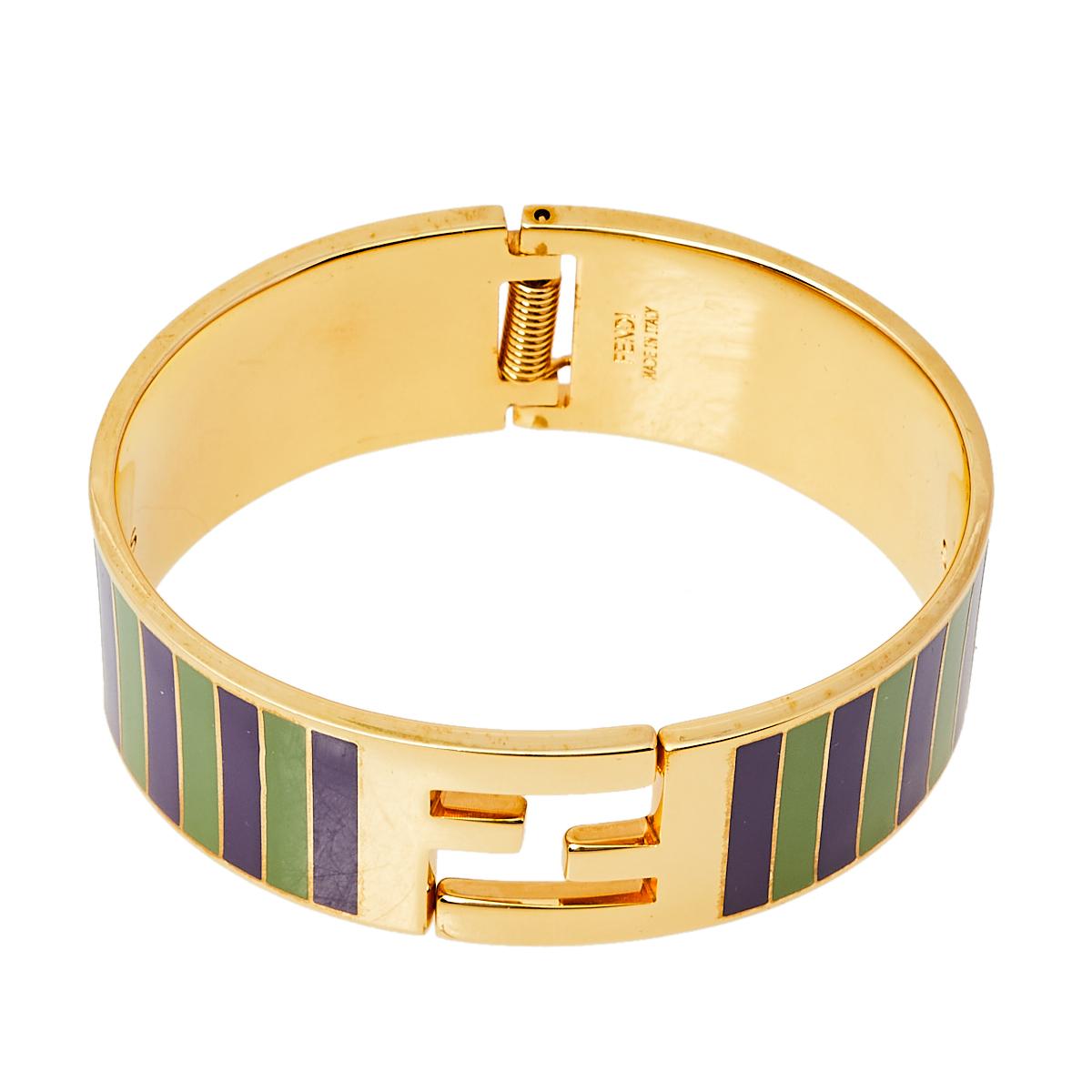Fendi has always strived to bring out something new and different, and this bracelet is no exception. Exquisitely crafted from gold-tone metal, this stunning creation features green and purple enamel stripes on the exterior and the signature FF