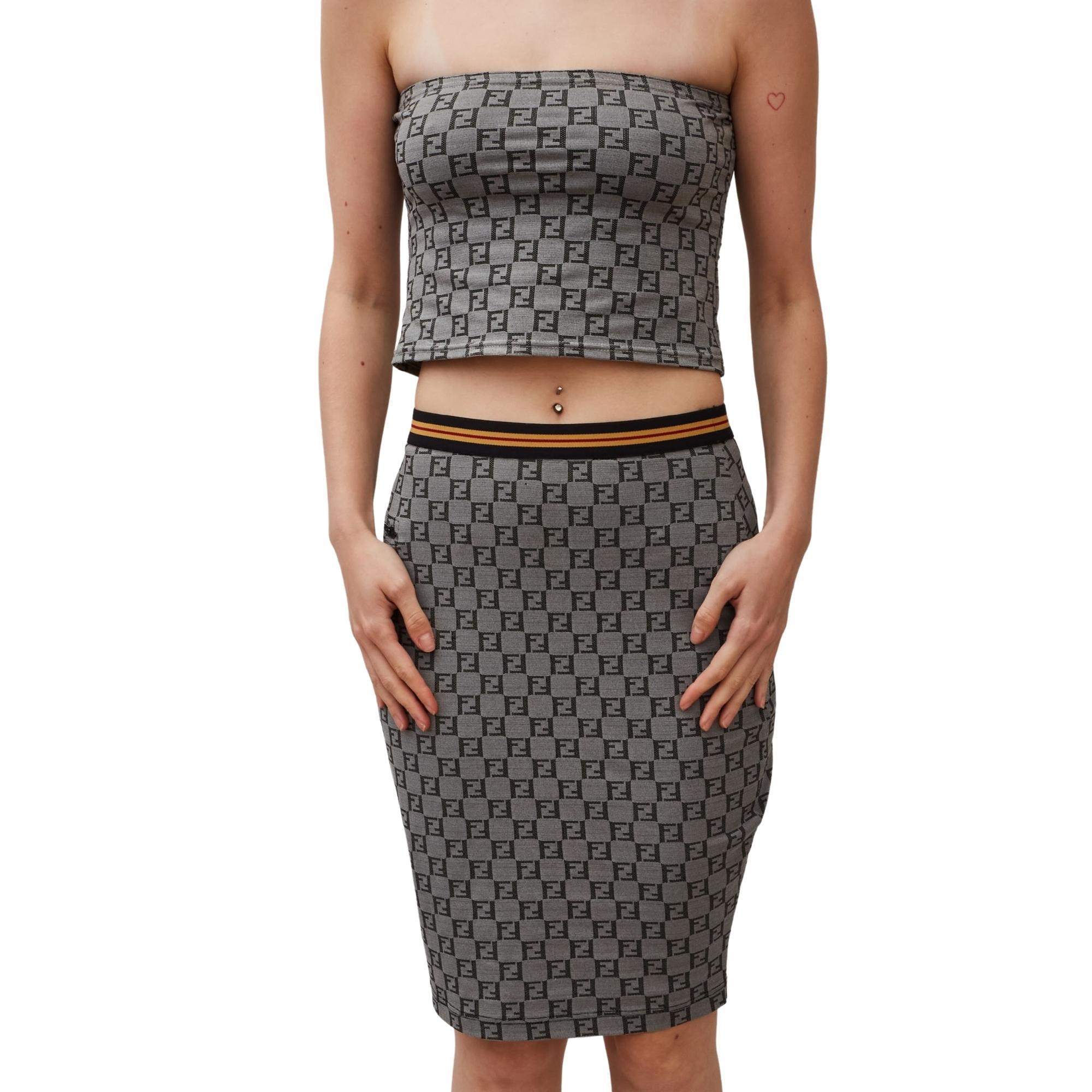 Fendi repurposed 2 piece set. Item was a dress, but was tailored to make a two piece. Fabric feels stretchy.

COLOR: Grey
MATERIAL: Not listed, feels like synthetic blend.

SIZE: Medium

MEASURES
SKIRT
Waist: 30”
Length: 20”
TOP
Bust: